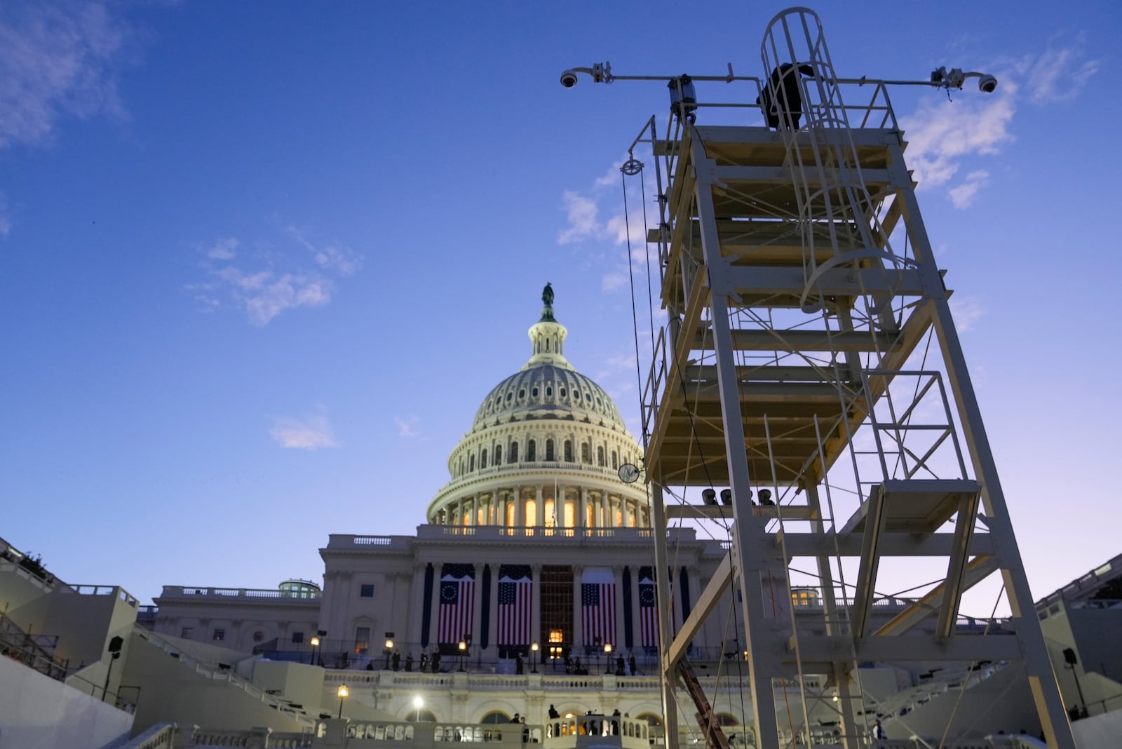 The sun rises behind the U.S. Capitol as a rehearsal takes place on the West Front ahead of President-elect Donald Trump's upcoming inauguration, Sunday, Jan. 12, 2025, in Washington. (AP Photo/Jon Elswick)