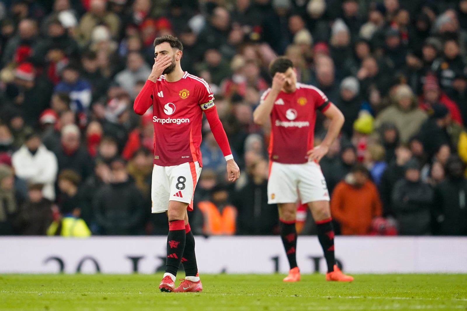 Manchester United's Bruno Fernandes, left, and Harry Maguire react after Brighton scored its side third goal during the English Premier League soccer match between Manchester United and Brighton and Hove Albion, at the Old Trafford stadium in Manchester, England, Sunday, Jan. 19, 2025. (AP Photo/Dave Thompson)