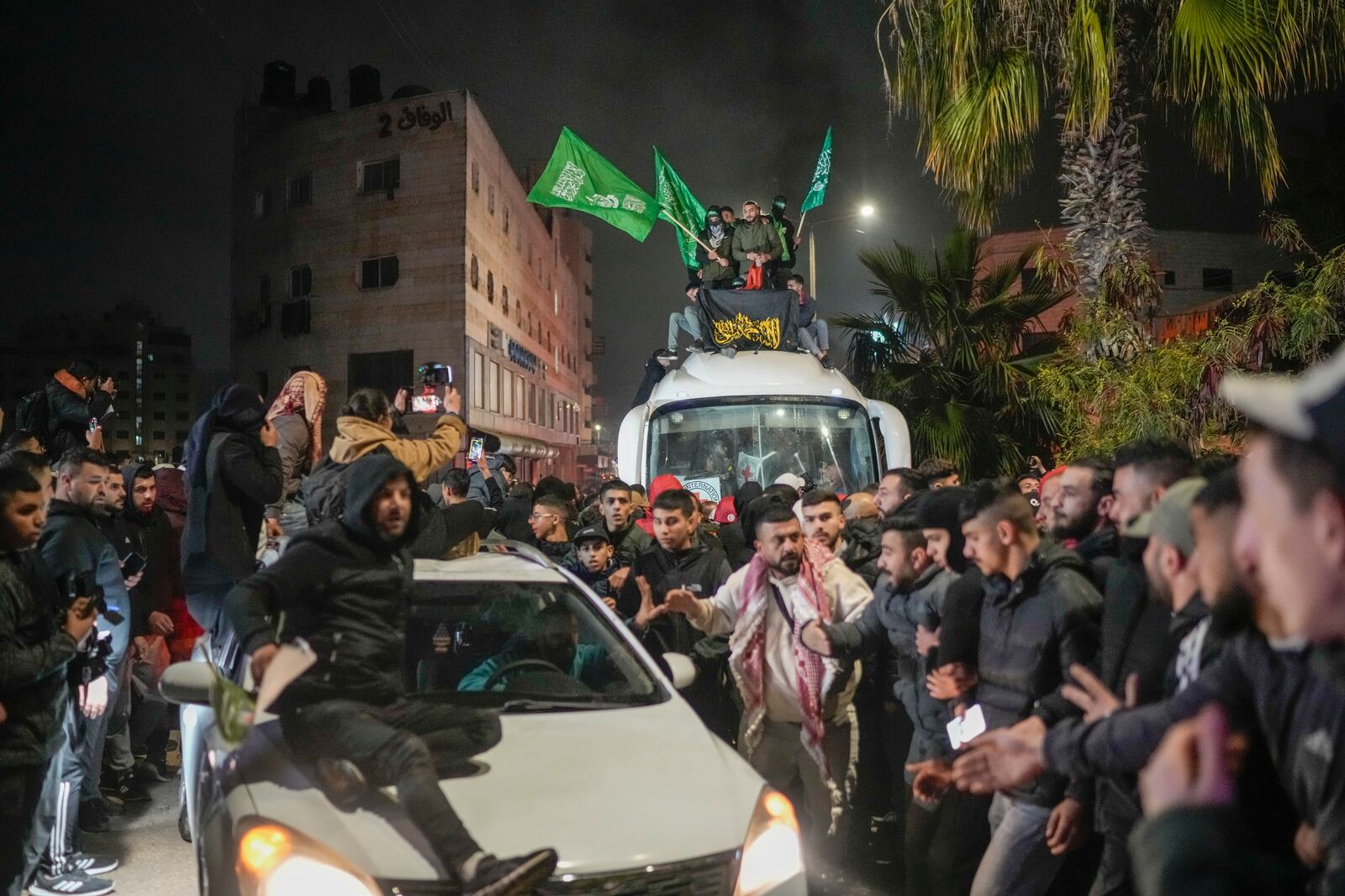 A crowd gathers around a bus carrying released Palestinian prisoners as it arrives in the West Bank city of Beitunia, early Monday, Jan. 20, 2025. (AP Photo/Leo Correa)