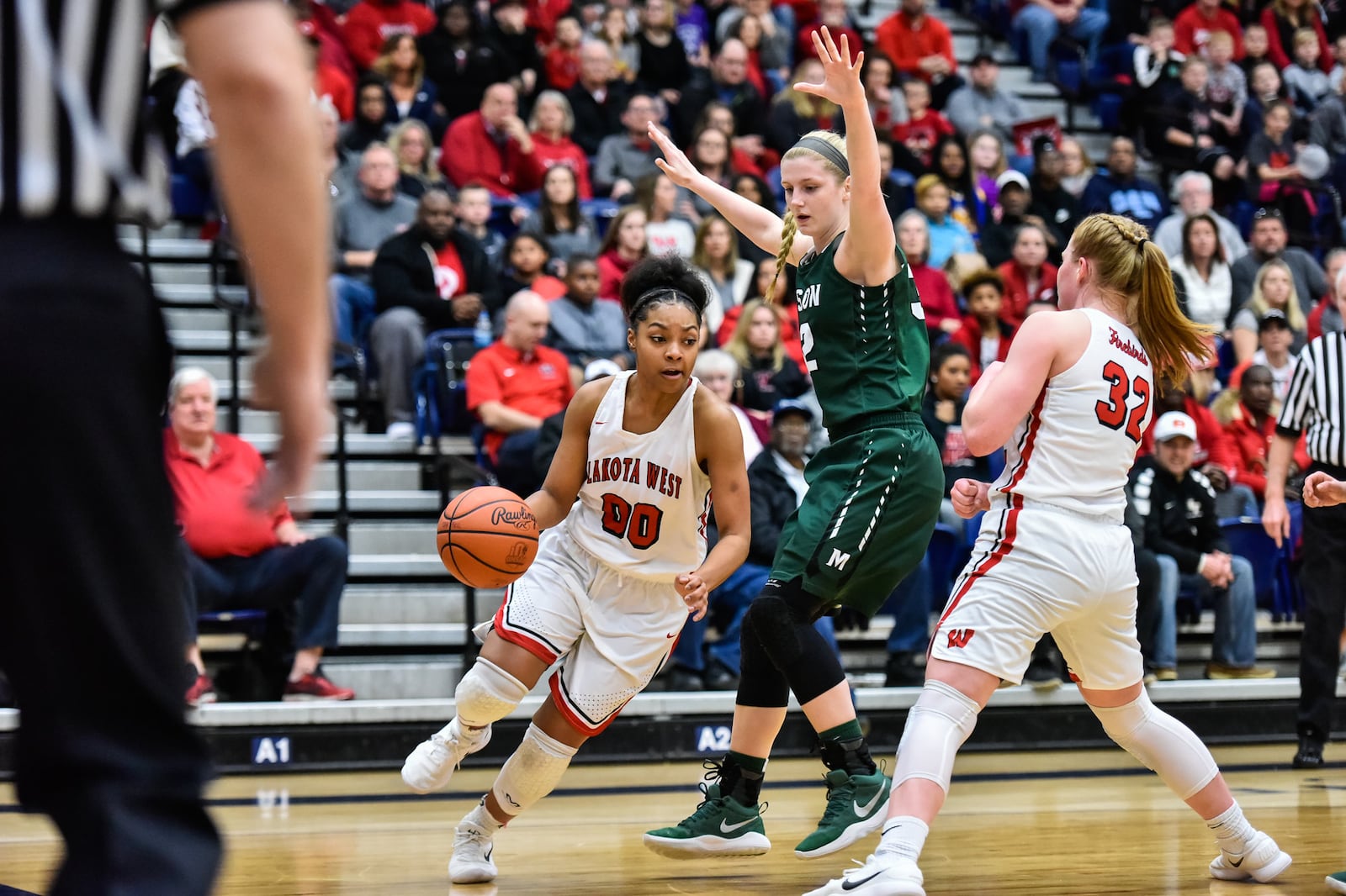 Lakota West's Jaydis Gales dribbles toward the hoop as teammate Abby Prohaska sets a pick on Mason’s Sammie Puisis during Saturday night’s Division I regional final at Fairmont’s Trent Arena. NICK GRAHAM/STAFF