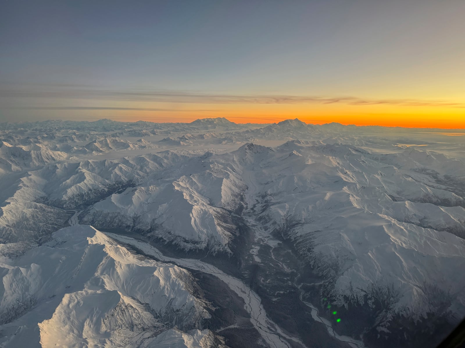 Snow-capped mountains out a side window in the cockpit of an Alaska Air National Guard C-17 Globemaster III as it nears Yakutat, Alaska, Jan. 12, 2022. (AP Photo/Mark Thiessen)