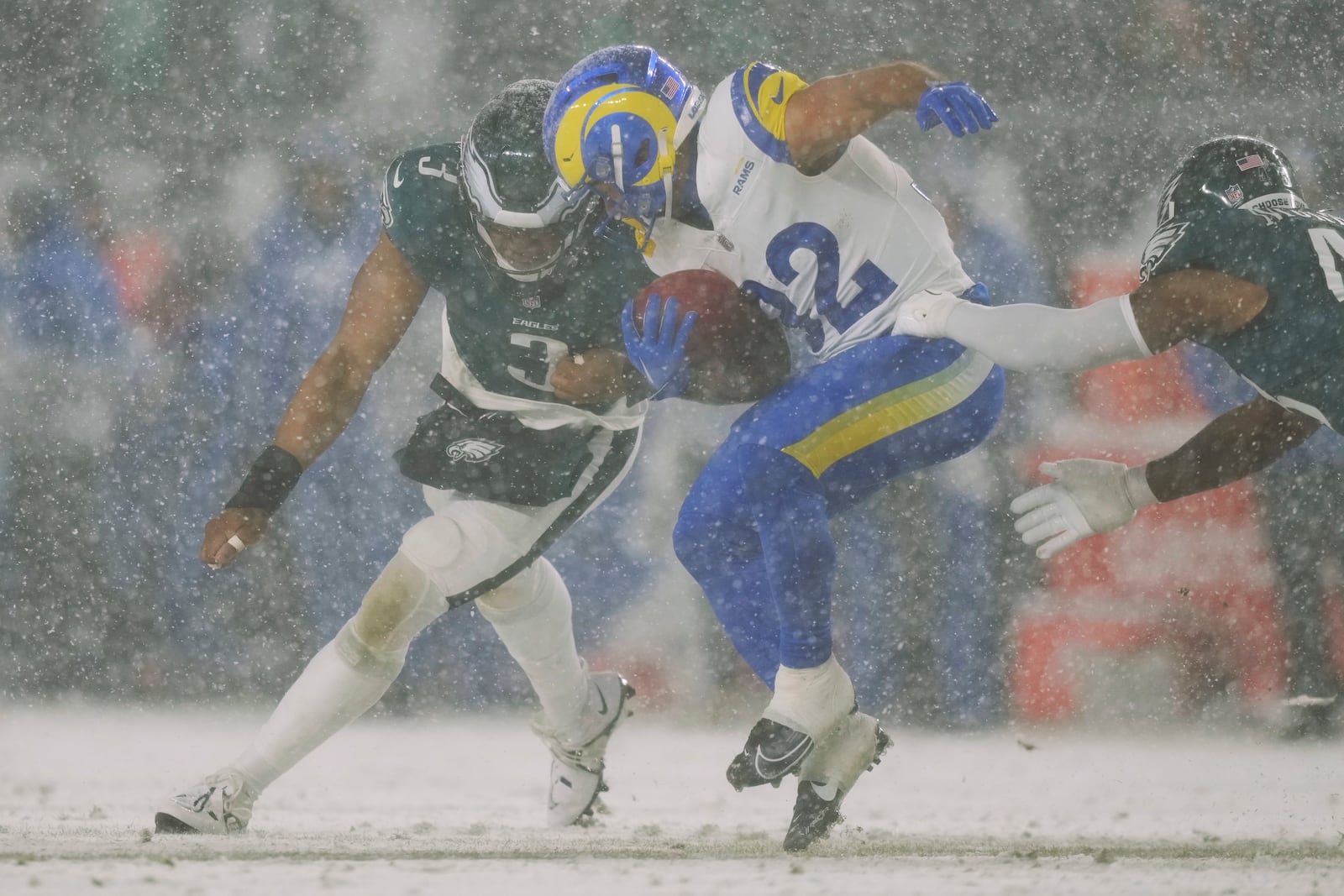 Los Angeles Rams running back Cody Schrader (32) is stopped with the ball by Philadelphia Eagles linebacker Nolan Smith Jr. (3) and Philadelphia Eagles linebacker Nicholas Morrow, right, during the second half of an NFL football NFC divisional playoff game Sunday, Jan. 19, 2025, in Philadelphia. (AP Photo/Matt Slocum)