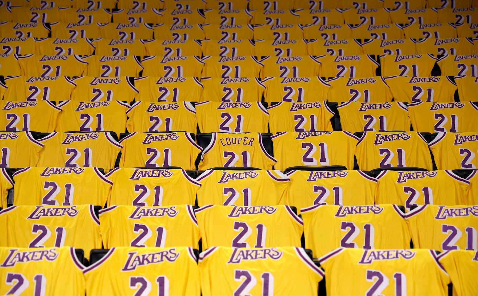 Jerseys with the number of former Los Angeles Lakers player Michel Cooper are left for fans on seats before an NBA basketball game between the Lakers and the San Antonio Spurs, Monday, Jan. 13, 2025, in Los Angeles. Cooper's No. 21 jersey will be raised into the rafters during halftime. (AP Photo/Kevork Djansezian)