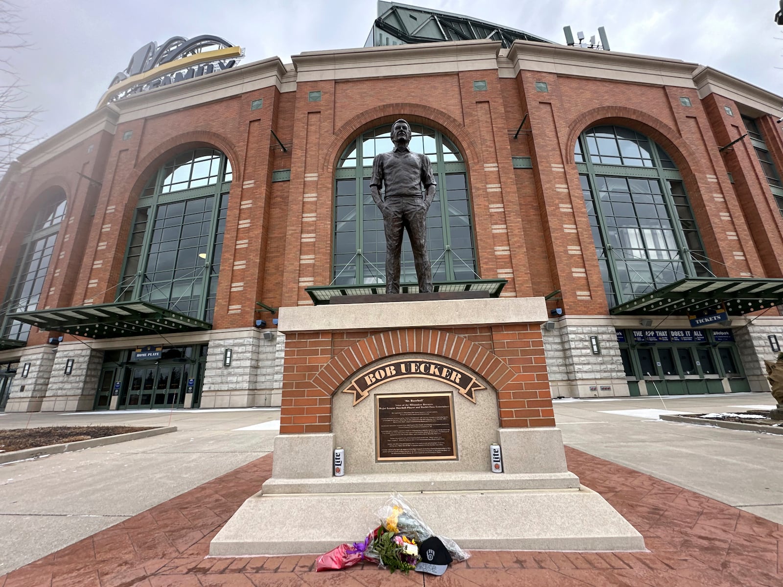 Flowers lay near a statue of Bob Uecker outside American Family Field in Milwaukee on Thursday, Jan. 16, 2025. (AP Photo/Steve Megargee)