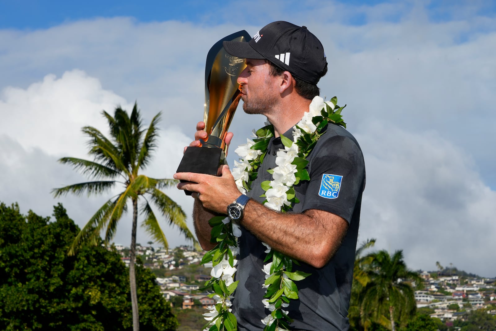 Nick Taylor, of Canada, kisses his trophy after winning the Sony Open golf event, Sunday, Jan. 12, 2025, at Waialae Country Club in Honolulu. (AP Photo/Matt York)