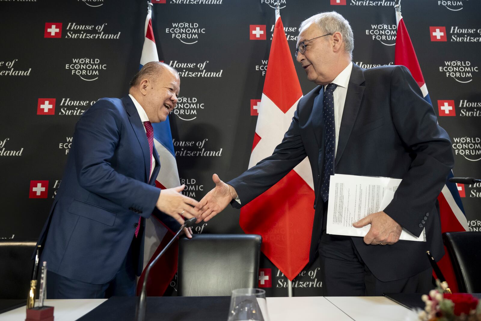 Thailand's Minister of Commerce Pichai, left, shake hands with Switzerland's Economy Minister Federal Councillor Guy Parmelin during the signing Ceremony of the Free Trade Agreement between the EFTA States and the Kingdom of Thailand at the House of Switzerland, during the World Economic Forum, WEF, in Davos, Switzerland, Thursday, January 23, 2025. (Laurent Gillieron/Keystone via AP)