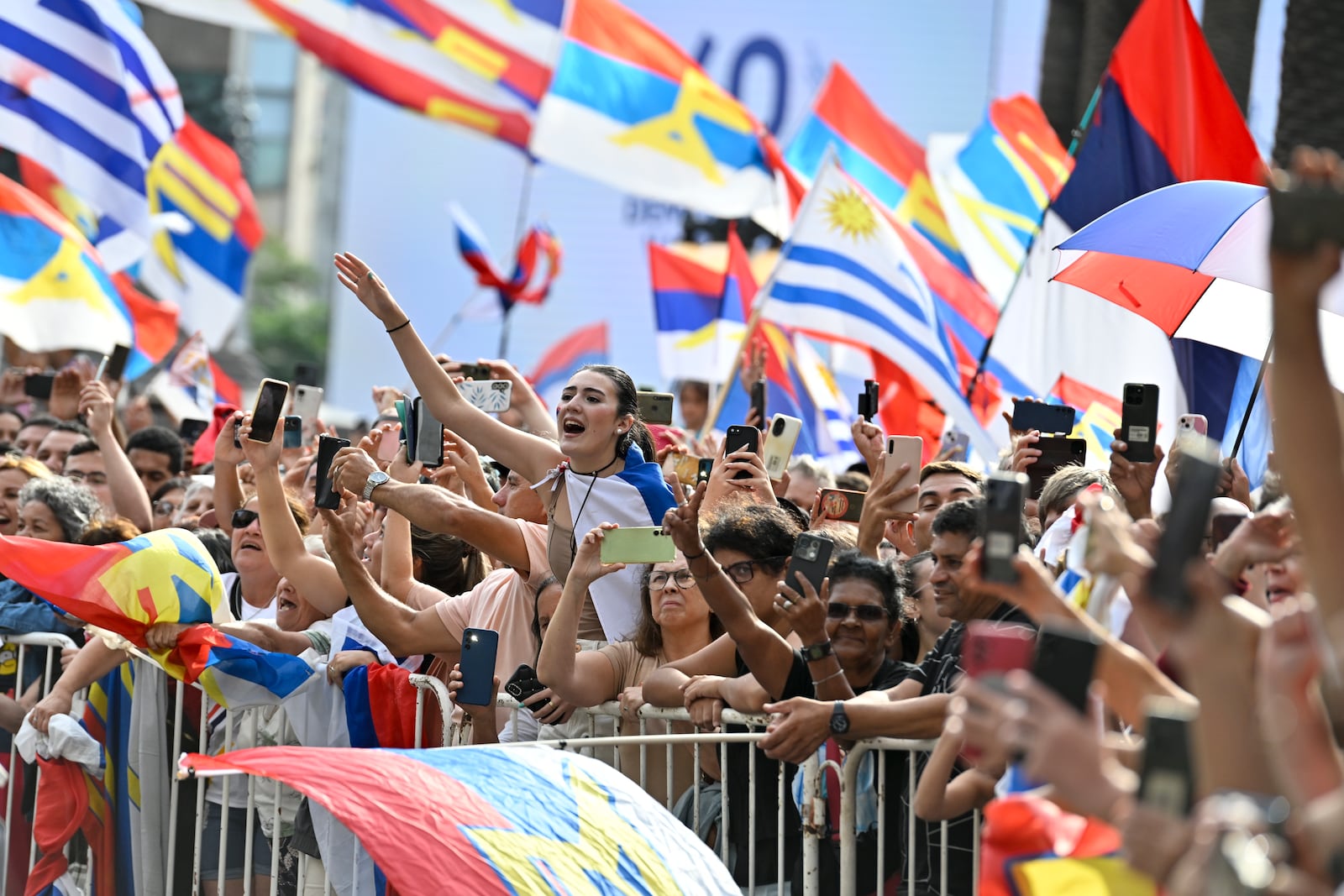 People greet Uruguay's newly sworn-in President Yamandu Orsi and Vice President Carolina Cosse as they ride past in an open car, on Inauguration Day in Montevideo, Uruguay, Saturday, March 1, 2025. (AP Photo/Santiago Mazzarovich)