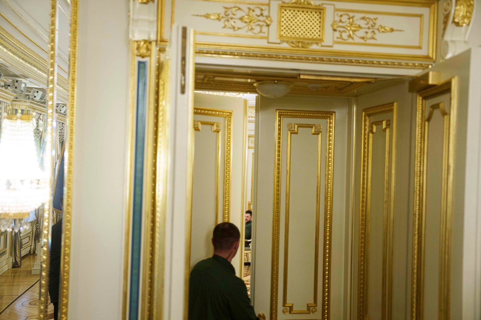 Ukraine's President Volodymyr Zelenskyy is seen through the doorway during his meeting with U.S. Special Envoy for Ukraine and Russia Keith Kellogg, in Kyiv, Ukraine, Feb. 20, 2025. (AP Photo/Evgeniy Maloletka)