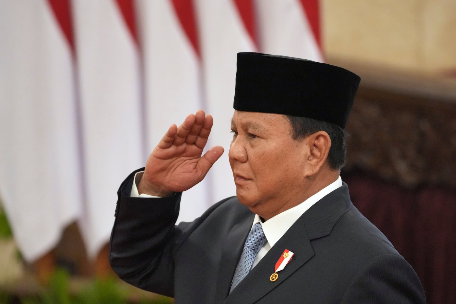 Indonesian President Prabowo Subianto salutes during the swearing-in ceremony of the new cabinet ministers at the presidential palace in Jakarta, Indonesia, Monday, Oct. 21, 2024. (AP Photo/Achmad Ibrahim)