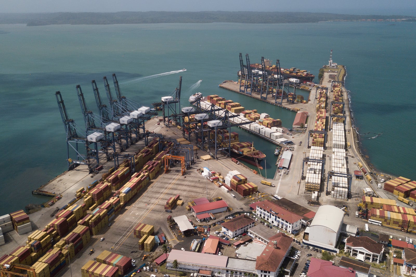 Cargo containers sit stacked as cranes load and unload containers from cargo ships at the Cristobal port, operated by the Panama Ports Company, in Colon, Tuesday, Panama, Feb. 4, 2025. (AP Photo/Matias Delacroix)