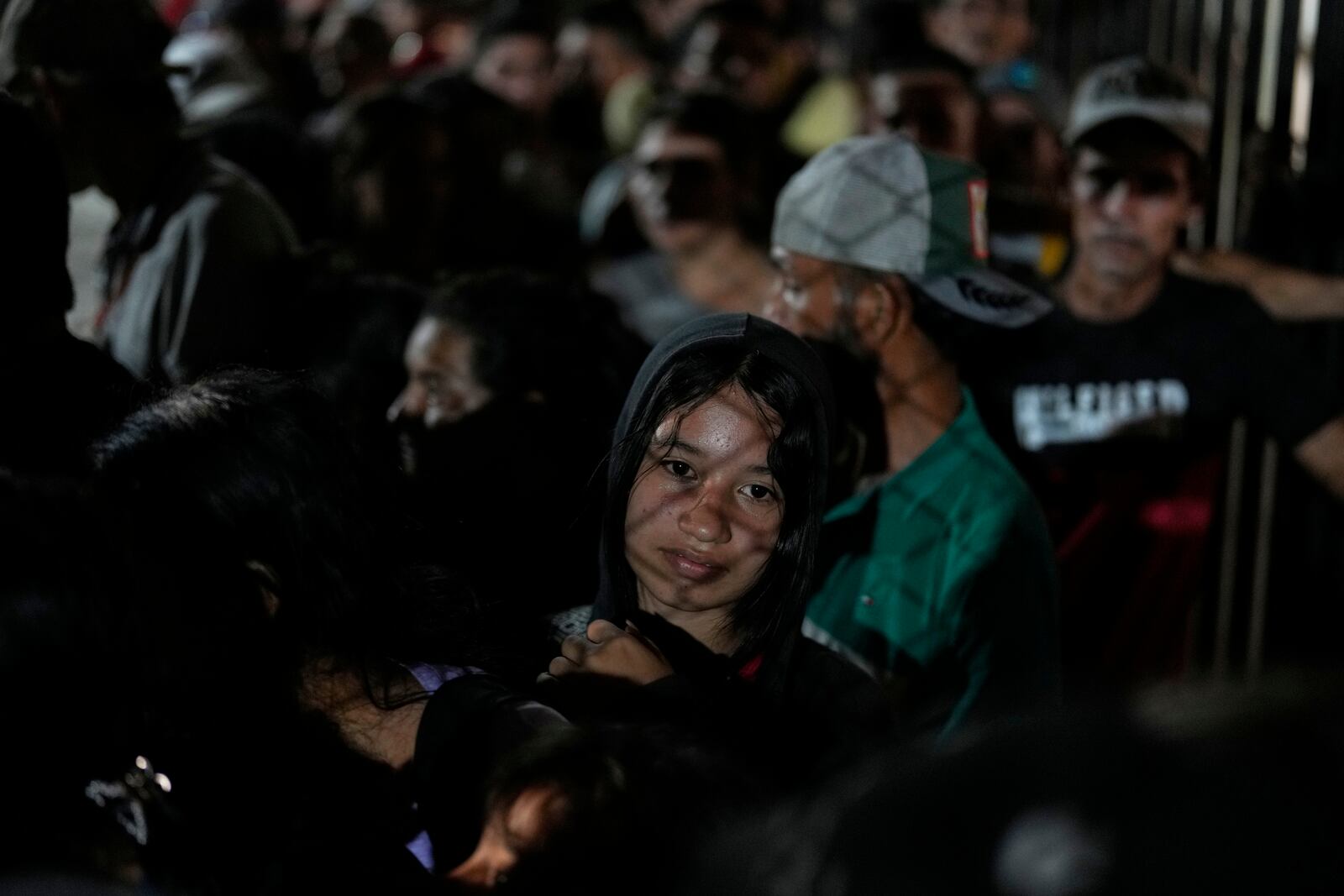 People displaced by violence in towns across the Catatumbo region, where rebels of the National Liberation Army, or ELN, have been clashing with former members of the Revolutionary Armed Forces of Colombia, line up to register for shelter at a soccer stadium in Cúcuta, Colombia, Sunday, Jan. 19, 2025. (AP Photo/Fernando Vergara)