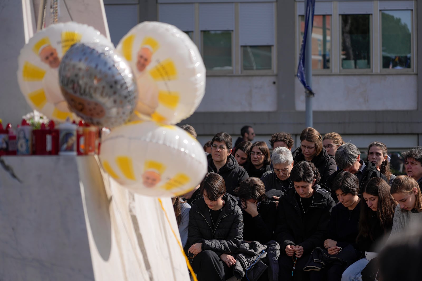 People pray outside the Agostino Gemelli Polyclinic in Rome, Sunday, Feb. 23, 2025, where Pope Francis is hospitalized since Feb. 14. (AP Photo/Gregorio Borgia)