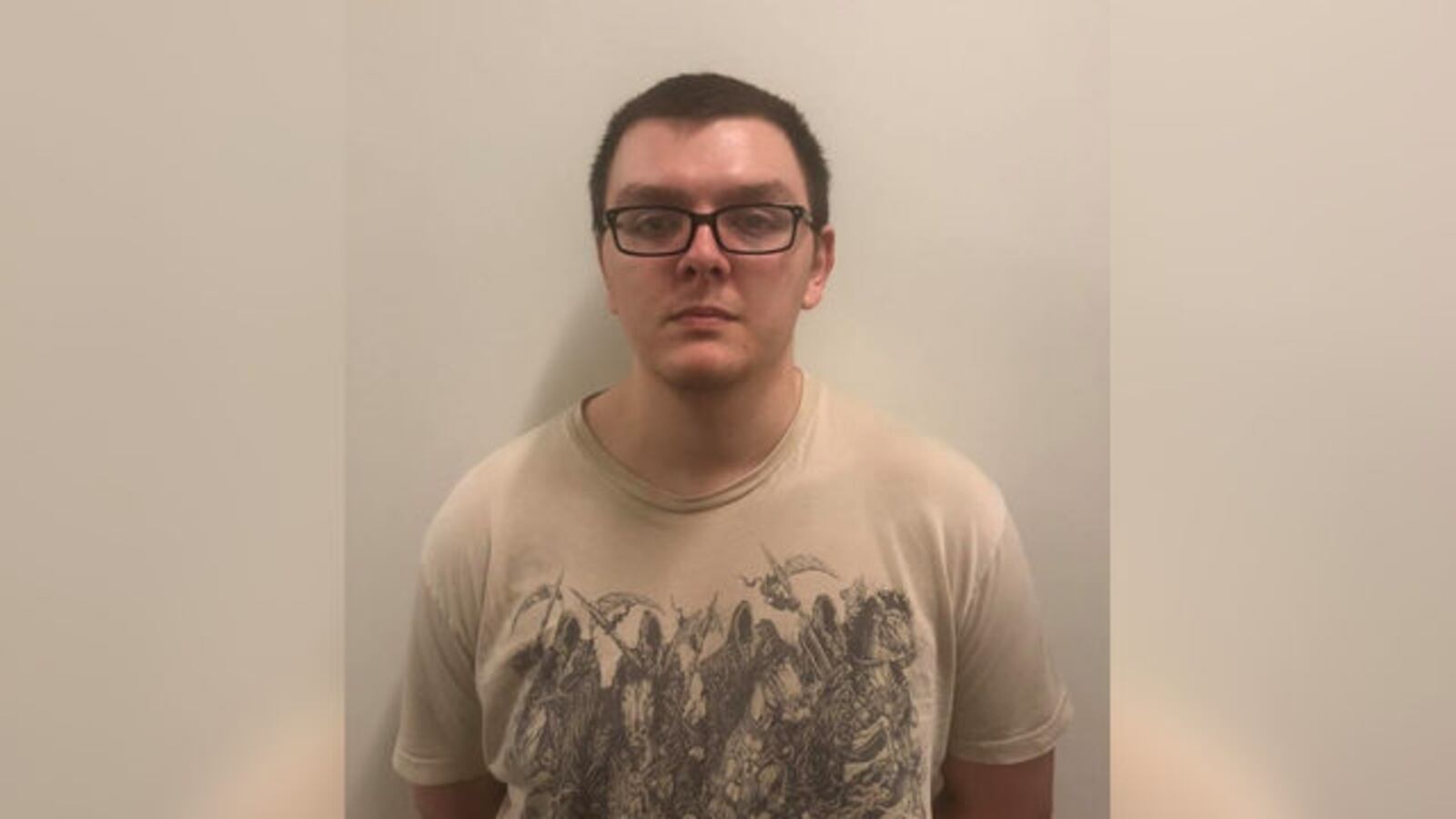 A booking photo of suspected mass bank killer Zepehn Xaver. He appears to be wearing a tan T-shirt depicting the Four Horsemen of the Apocalypse.