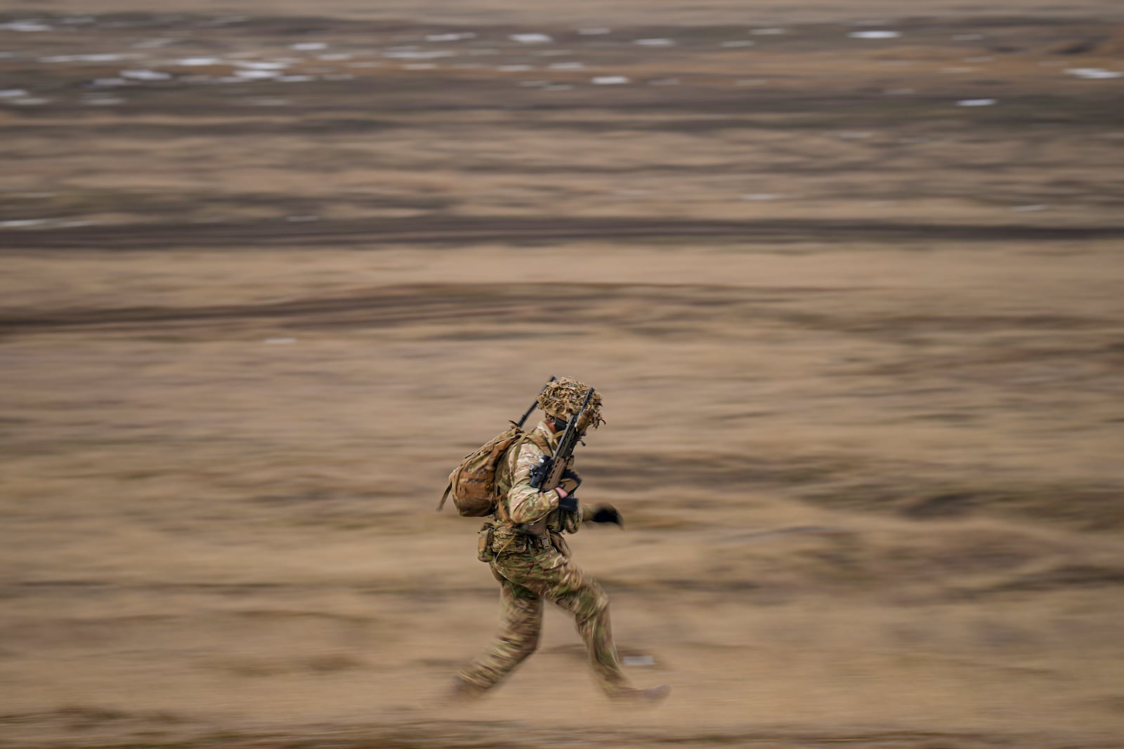 A British IRF serviceman runs during the Steadfast Dart 2025 exercise, involving some 10,000 troops in three different countries from nine nations and represent the largest NATO operation planned this year, at a training range in Smardan, eastern Romania, Wednesday, Feb. 19, 2025. (AP Photo/Vadim Ghirda)