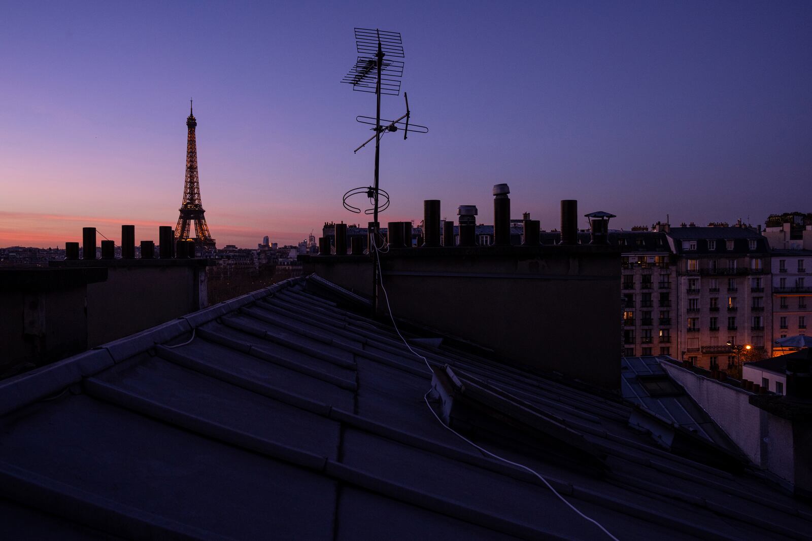 The Eiffel Tower and zinc roofs are seen at sunset in Paris, Thursday, Nov. 28, 2024. (AP Photo/Louise Delmotte)