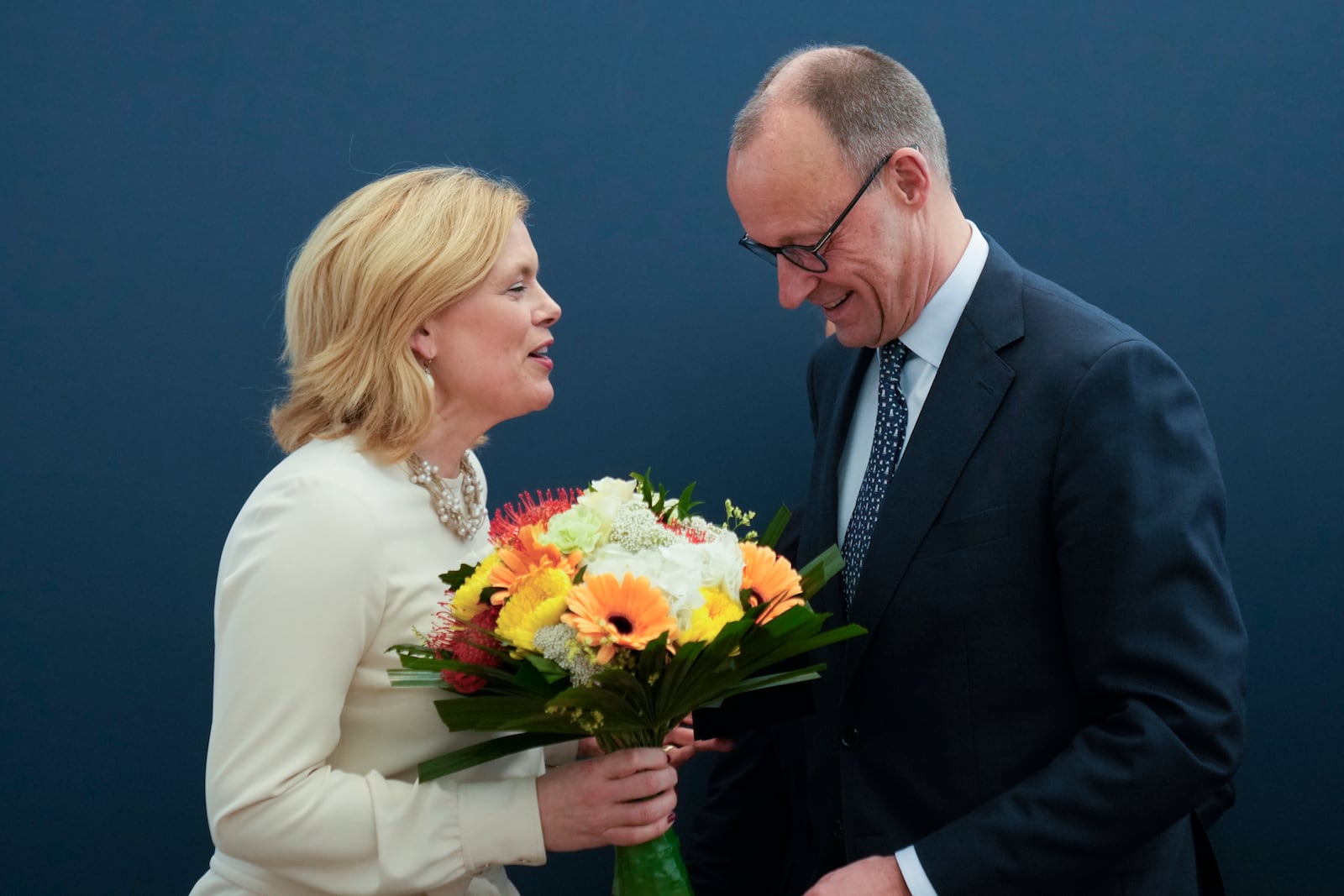 Friedrich Merz, right, leader of the Christian Democratic Union (CDU), receives flowers from Julia Kloeckner, left, treasurer of the party at the CDU's headquarters, in Berlin, Germany, Monday, Feb. 24, 2025. (AP Photo/Martin Meissner)