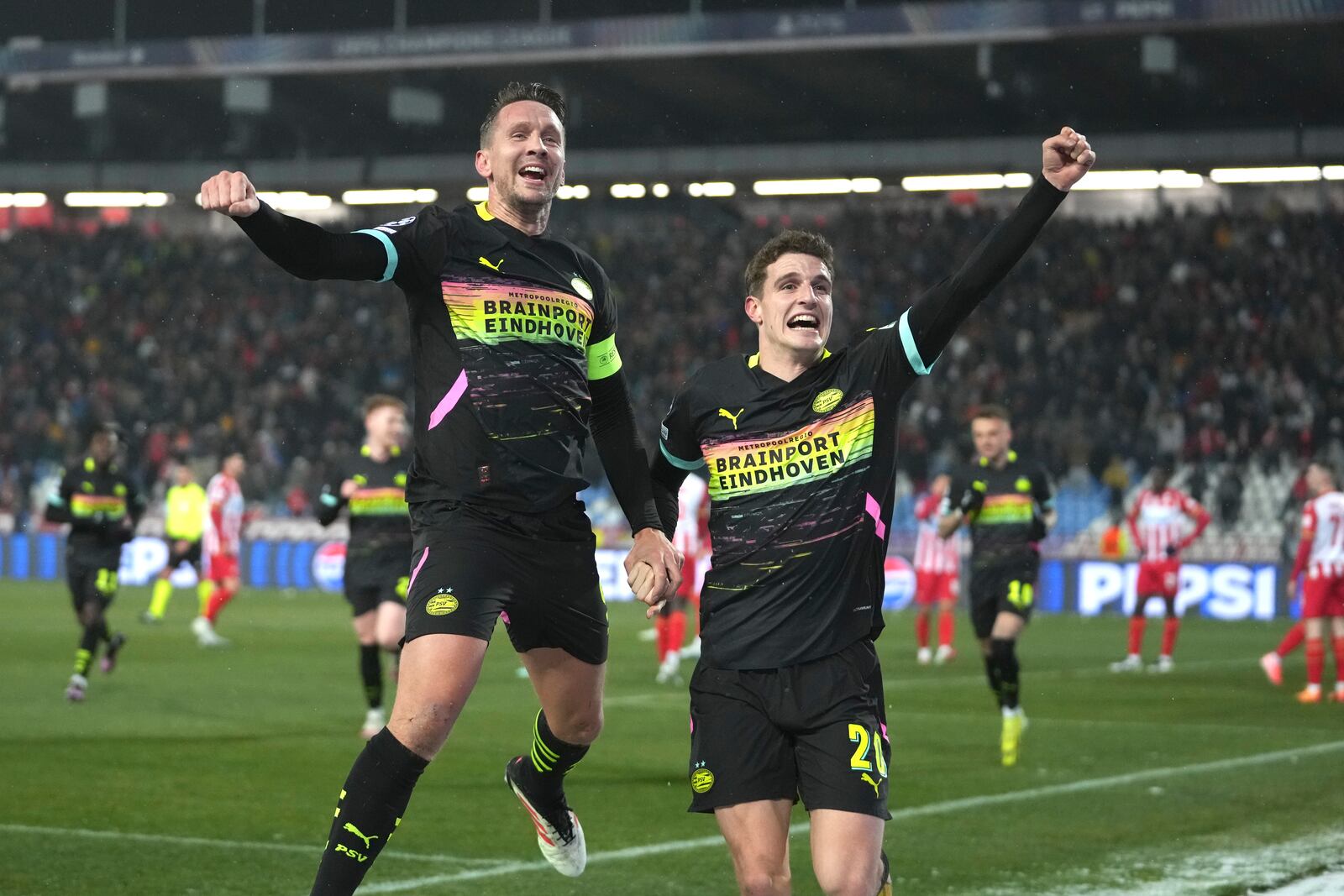 PSV's Luuk de Jong, centre, celebrates with PSV's Guus Til after scoring his side's second goal during the Champions League opening phase soccer match between Red Star and PSV at the Rajko Mitic Stadium in Belgrade, Serbia, Tuesday, Jan. 21, 2025. (AP Photo/Darko Vojinovic)