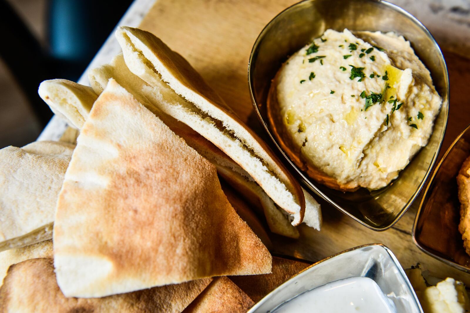 The trio platter at Skally’s featuring regular and spicy hummus and tzatziki sauce with pita bread and vegetables. 