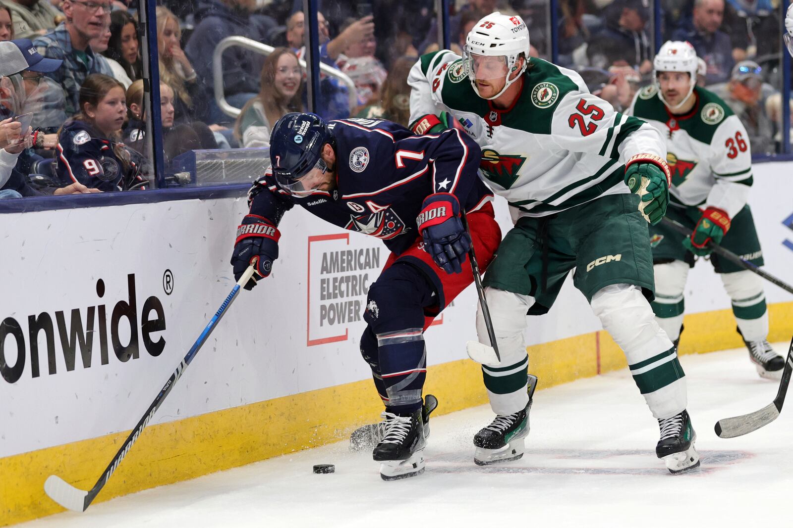 Columbus Blue Jackets forward Sean Kuraly, left, chases the puck in front of Minnesota Wild defenseman Jonas Brodin during the second period of an NHL hockey game in Columbus, Ohio, Saturday, Oct. 19, 2024. (AP Photo/Paul Vernon)