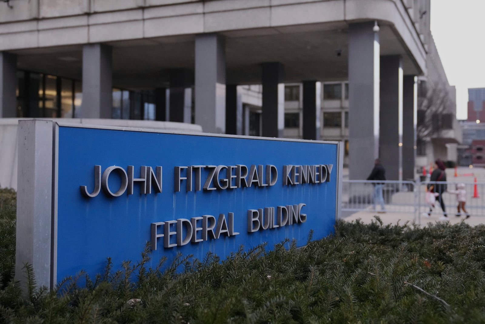 Pedestrians walk towards the John F. Kennedy Federal Building, Tuesday, March 4, 2025, in Boston. (AP Photo/Charles Krupa)