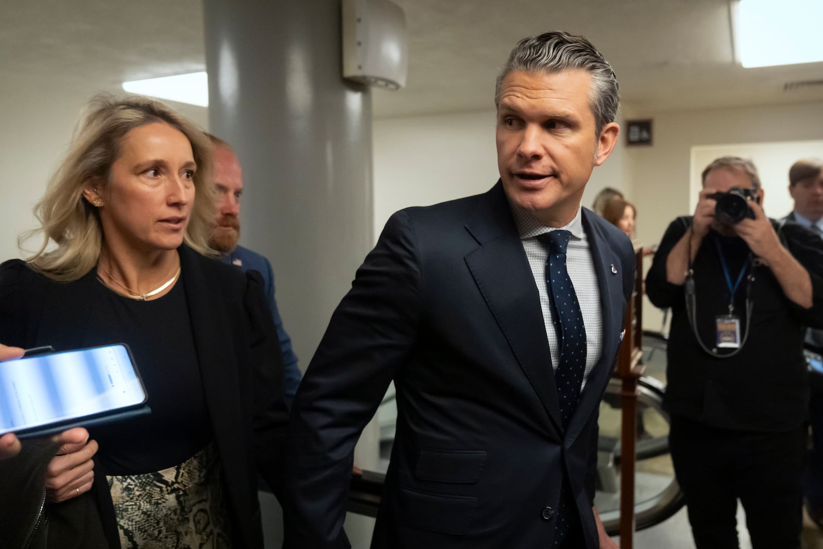 Pete Hegseth, President-elect Donald Trump's nominee to be defense secretary, is joined by his wife Jennifer Rauchet, as they walk through the basement of the Capitol, Wednesday, Dec. 4, 2024, in Washington. (AP Photo/Mark Schiefelbein)