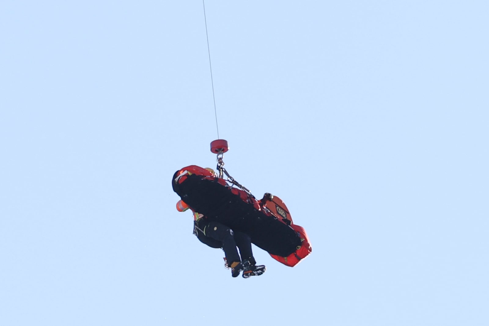 Italy's Pietro Zazzi is lifted by medical staff to an helicopter after crashing during an alpine ski, men's World Cup downhill training, in Bormio, Italy, Friday, Dec. 27, 2024. (AP Photo/Marco Trovati)