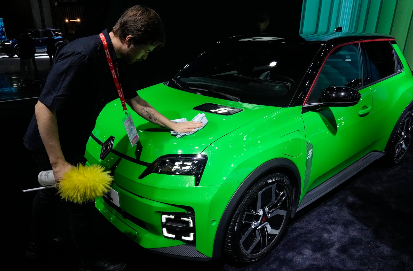 A man cleans a Renault R5 E-TECH car at the Paris Auto Show, in Paris, Monday, Oct. 14, 2024. (AP Photo/Michel Euler)