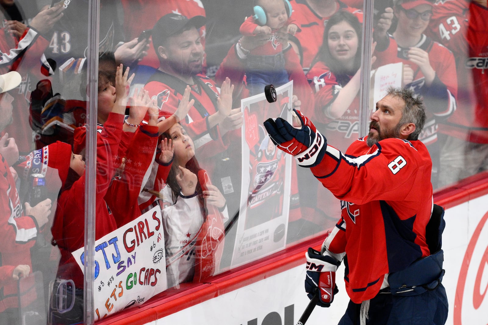 Washington Capitals left wing Alex Ovechkin (8) throws a puck to spectators during warm-ups before an NHL hockey game against the Philadelphia Flyers, Thursday, March 20, 2025, in Washington. (AP Photo/Nick Wass)