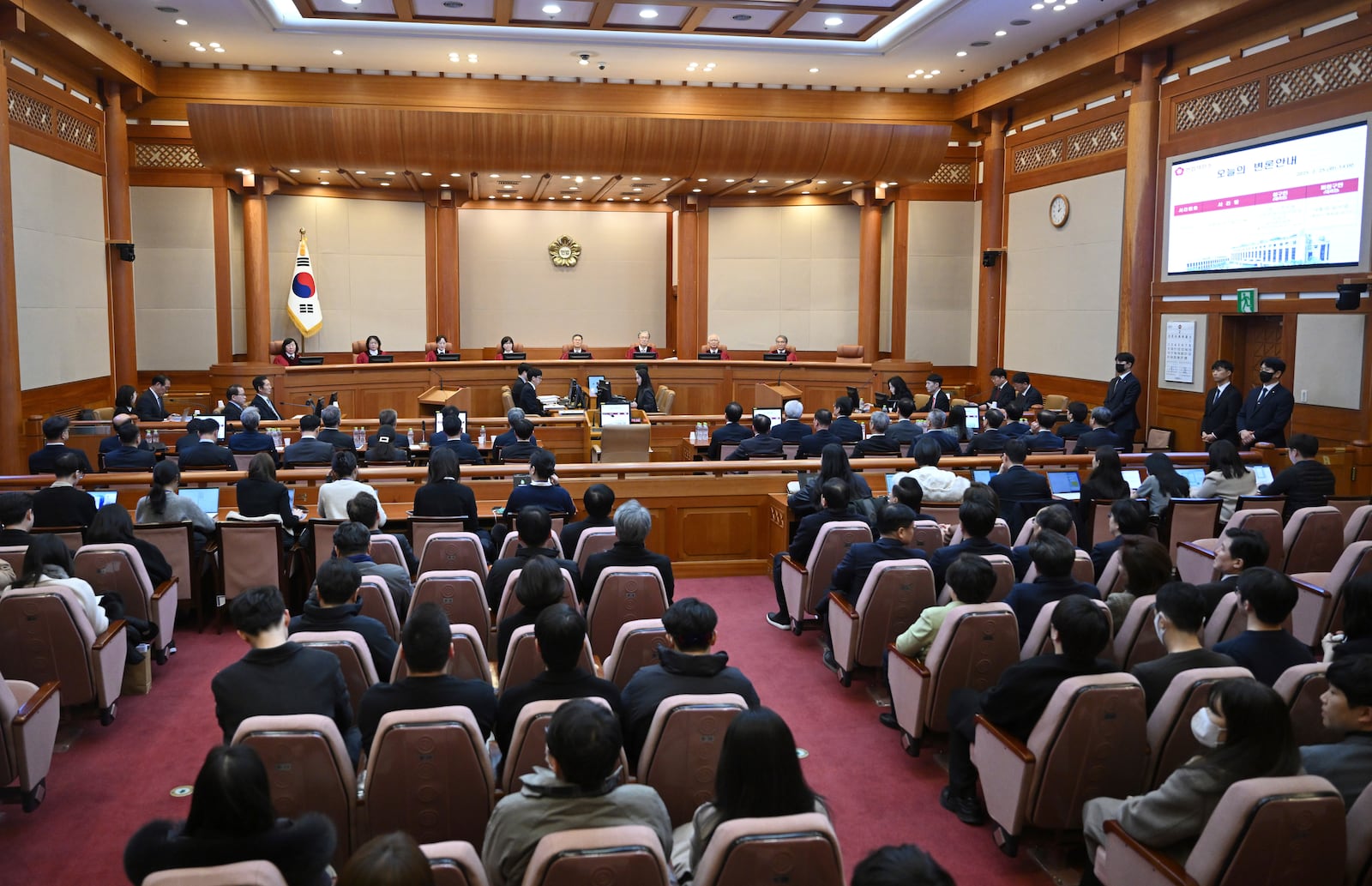 The Constitutional Court of Korea's eight justices, back, from left, Chung Kye-sun, Kim Bok-hyeong, Jung Jung-mi, Lee Mi-son, Moon Hyung-bae, Kim Hyung-du, Cheong Hyung-sik and Cho Han-chang sit in the courtroom during the final hearing over South Korea's impeached President Yoon Suk Yeol's imposition of martial law, at the Constitutional Court in Seoul, South Korea, Tuesday, Feb. 25, 2025. (Jung Yeon-je/Pool Photo via AP)