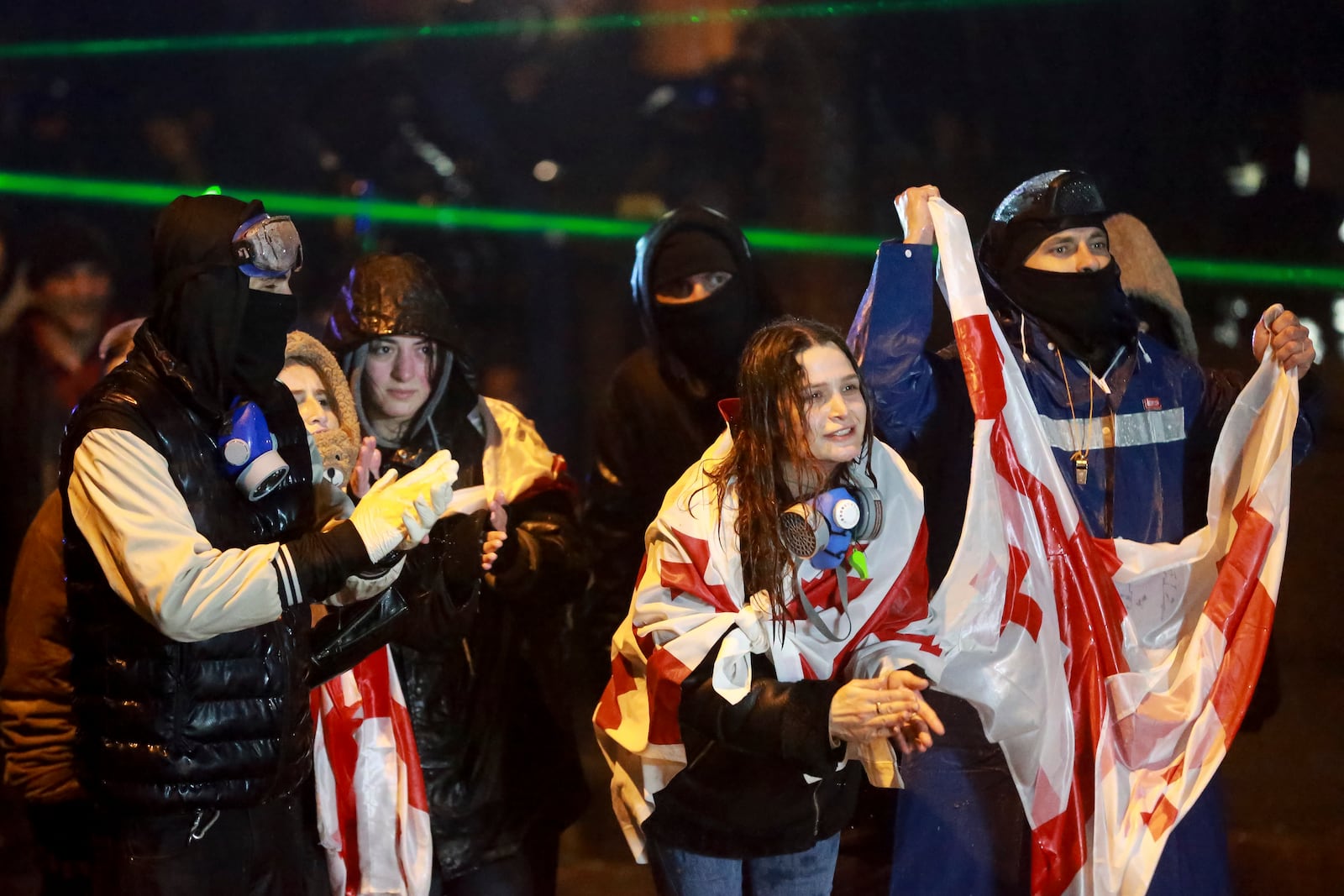 Protesters with Georgian national flags shout toward police during a rally against the governments' decision to suspend negotiations on joining the European Union for four years, outside the parliament's building in Tbilisi, Georgia, on Sunday, Dec. 1, 2024. (AP Photo/Zurab Tsertsvadze)