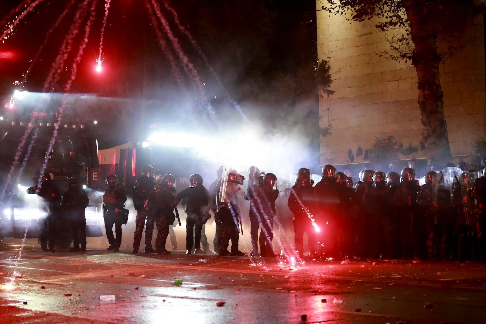 Demonstrators use petard against police as police blocked a street to prevent protesters rallying against the governments' decision to suspend negotiations on joining the European Union for four years, outside the parliament's building in Tbilisi, Georgia, early Saturday, Nov. 30, 2024. (AP Photo/Zurab Tsertsvadze)