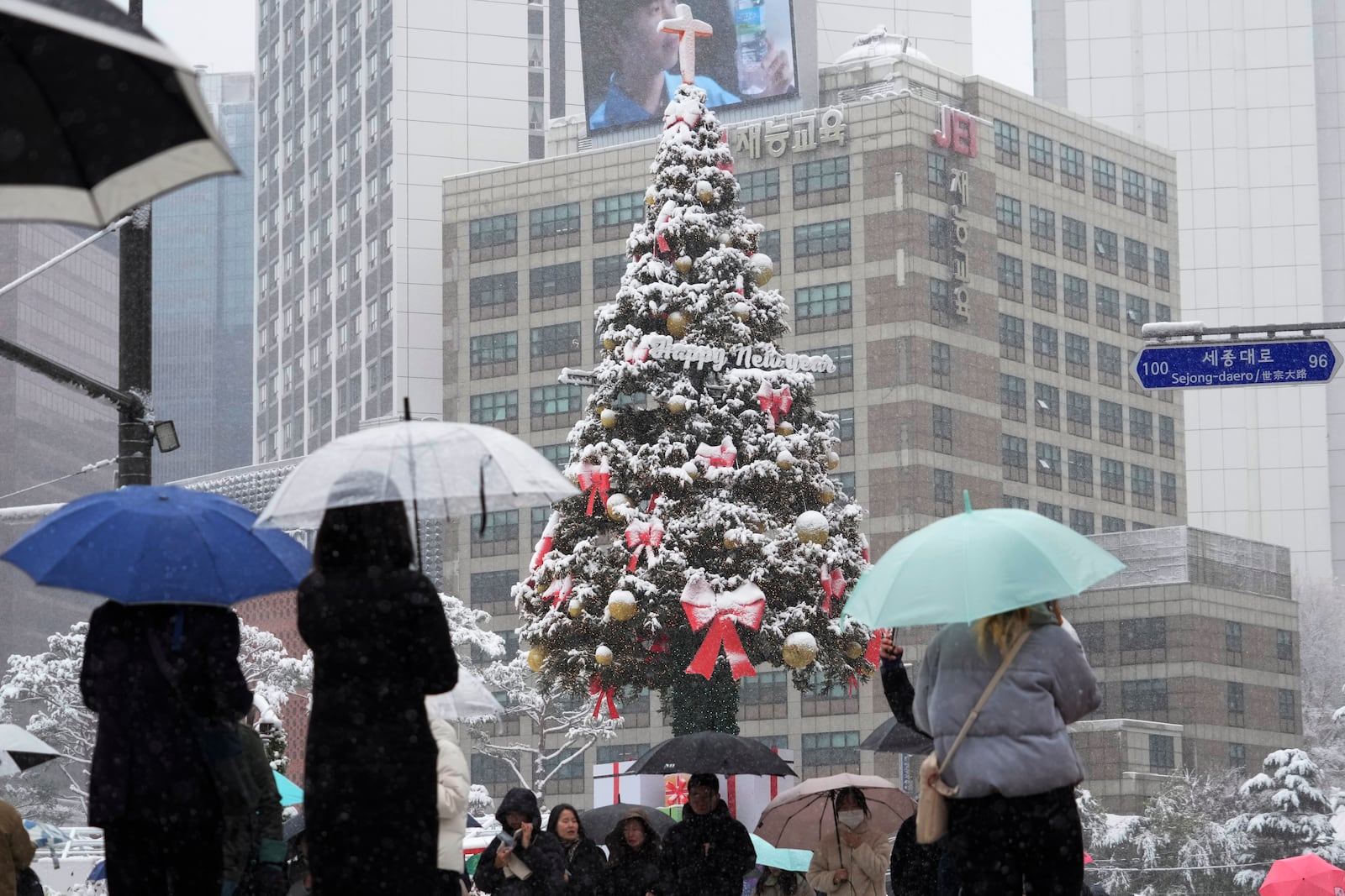 People pass by snow-covered a Christmas tree in Seoul, South Korea, Wednesday, Nov. 27, 2024. (AP Photo/Ahn Young-joon)