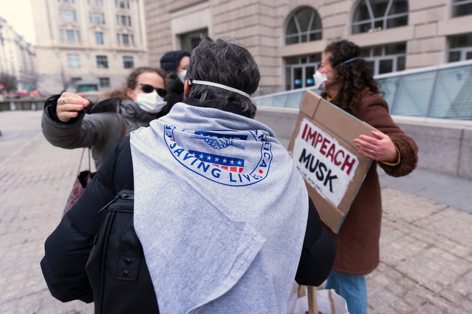 Contract workers for United States Agency for International Development, or USAID, hug outside the USAID headquarters in Washington, Monday, Feb. 10, 2025. (AP Photo/Manuel Balce Ceneta)