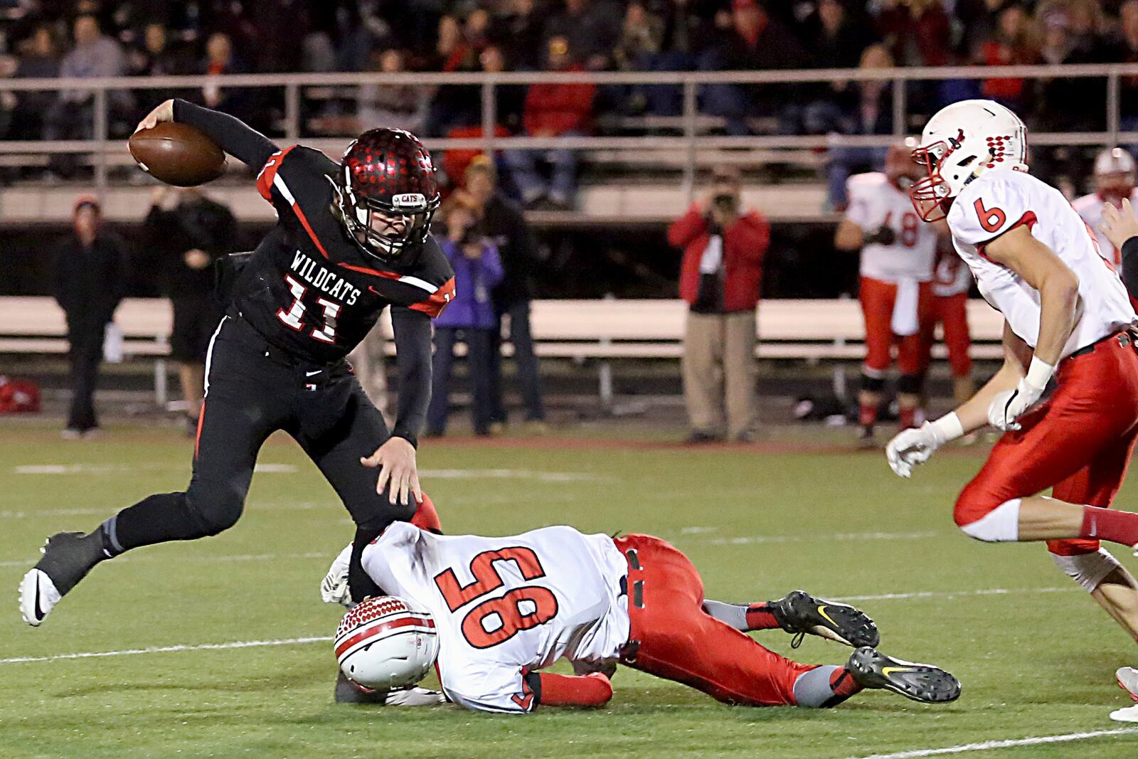 Franklin quarterback Braden White is pursued by Tippecanoe’s Bryce McCullough (85) and Quenten Williams on a fake punt during their Division III playoff game at Veterans Memorial Field in Franklin on Nov. 5, 2016. The host Wildcats won 41-40. CONTRIBUTED PHOTO BY E.L. HUBBARD