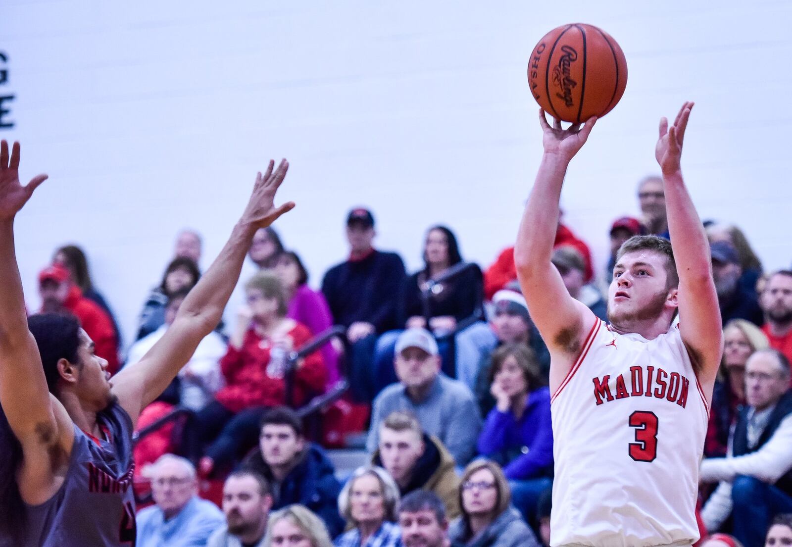 Madison’s Mason Whiteman shoots over Northridge’s Darryl Story Jr. during Friday night’s game in Madison Township. Northridge won 58-56. NICK GRAHAM/STAFF