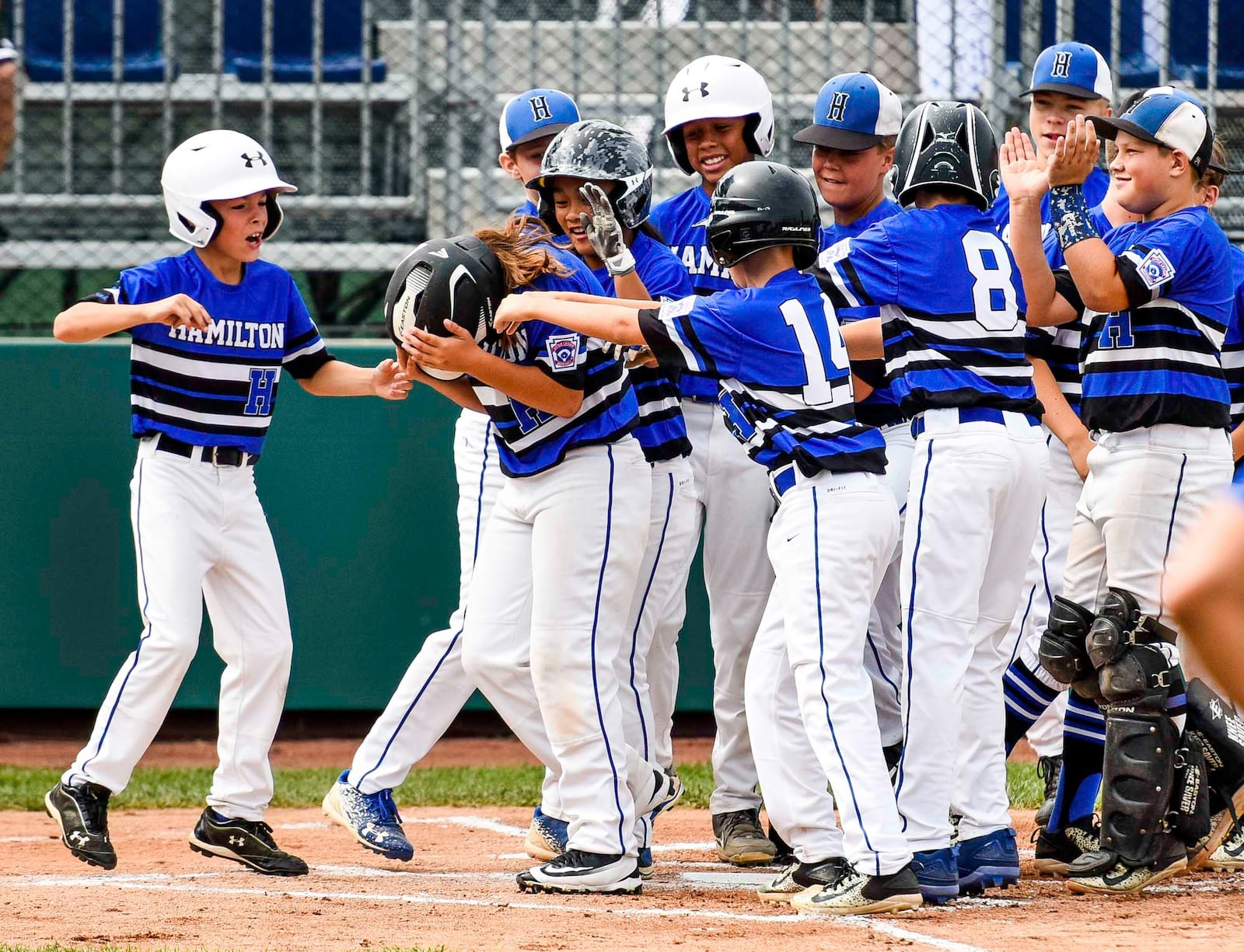 Teammates wait at home plate after West Side Little League's Jaycee Taylor hits a 2-run home run during their 10-2 win over Grosse Pointe Woods/Shores Little League, from Michigan, in their Little League Great Lakes Regional tournament Monday, Aug. 7 at Grand Park Sports Campus in Westfield, Indiana. NICK GRAHAM/STAFF