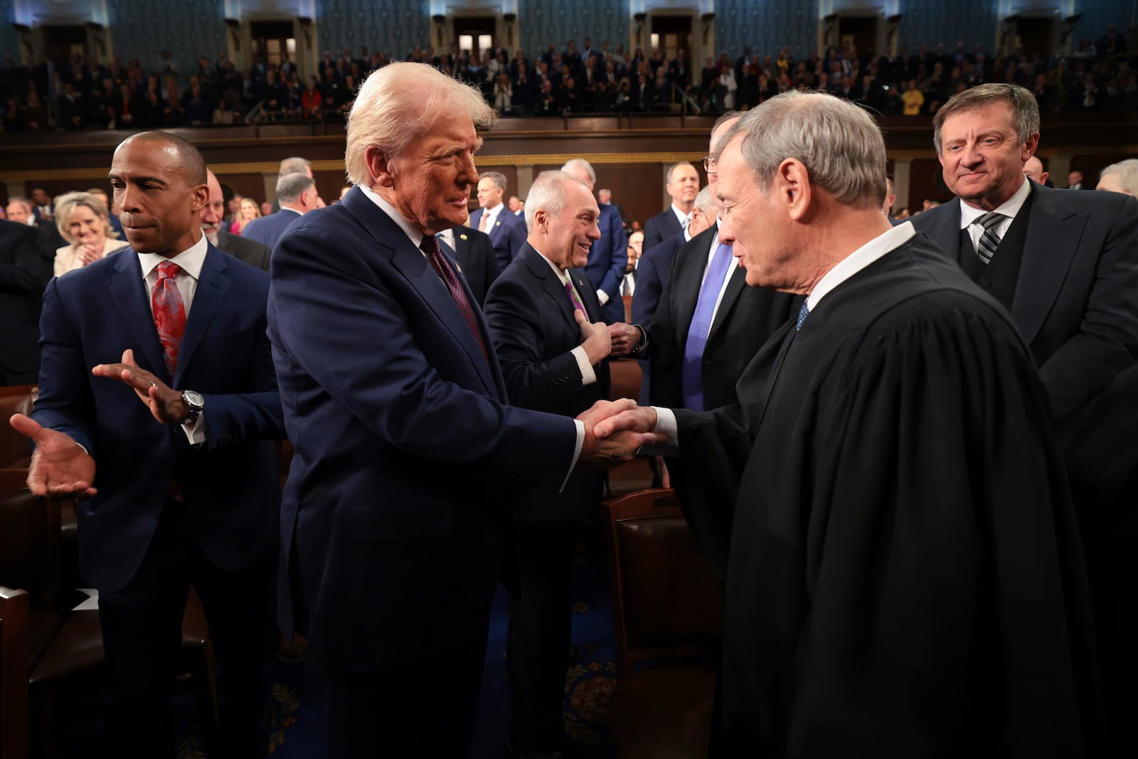 President Donald Trump, center, greets Chief Justice of the Supreme Court John Roberts, right, as he arrives to address a joint session of Congress at the Capitol in Washington, Tuesday, March 4, 2025. (Win McNamee/Pool Photo via AP)