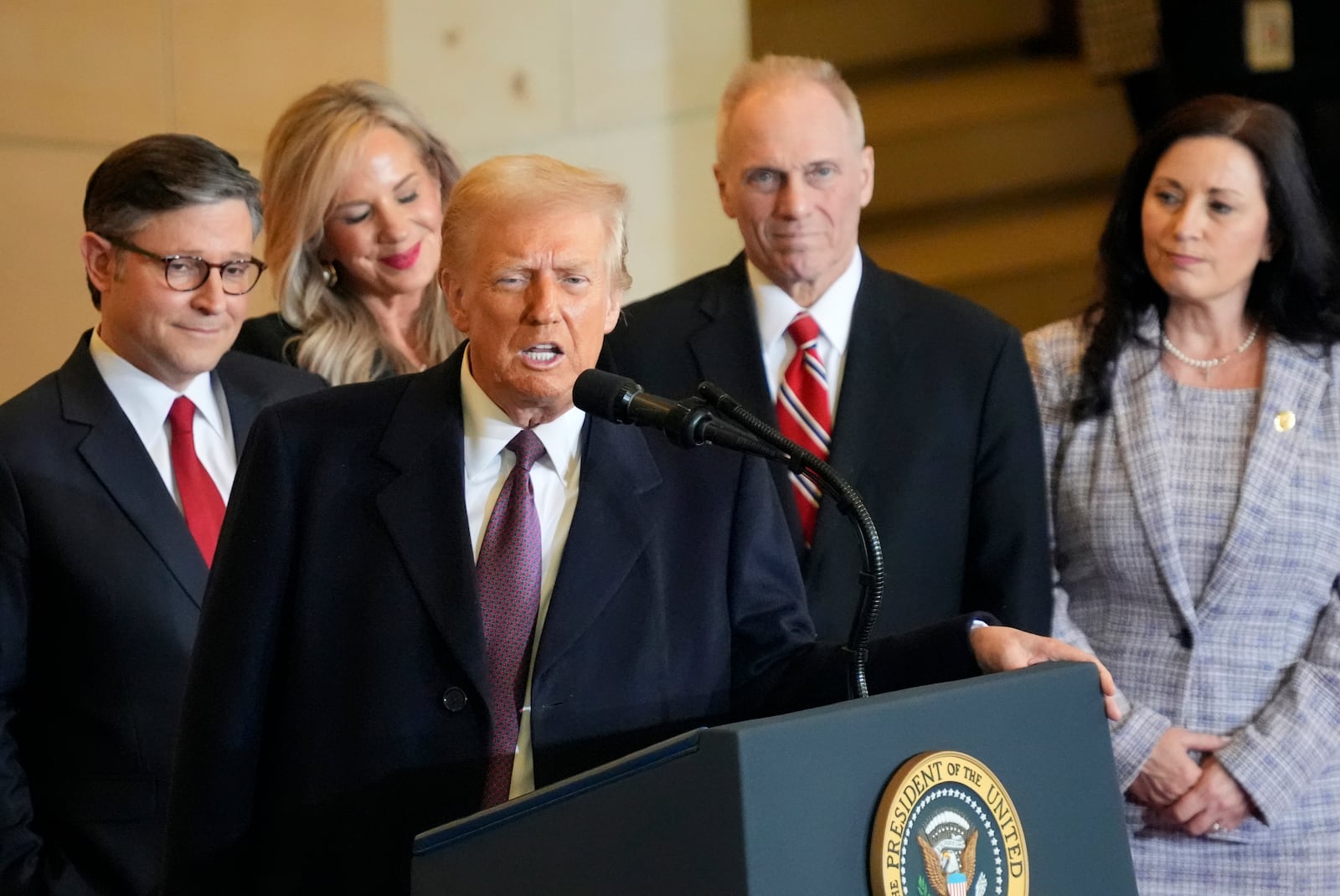 President Donald Trump speaks from Emancipation Hall as House Speaker Mike Johnson, from left, his wife Kelly Johnson, House Majority Leader Steve Scalise, R-La., and his wife Jennifer Scalise, listen after the 60th Presidential Inauguration, Monday, Jan. 20, 2025, at the U.S. Capitol in Washington. (Jasper Colt/Pool Photo via AP)