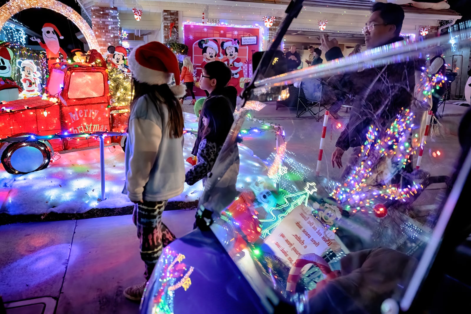 Local children walk the Wakefield Winter Wonderland neighborhood decorated with Christmas lights in Santa Clarita, Calif. on Dec. 17, 2024. (AP Photo/Richard Vogel)