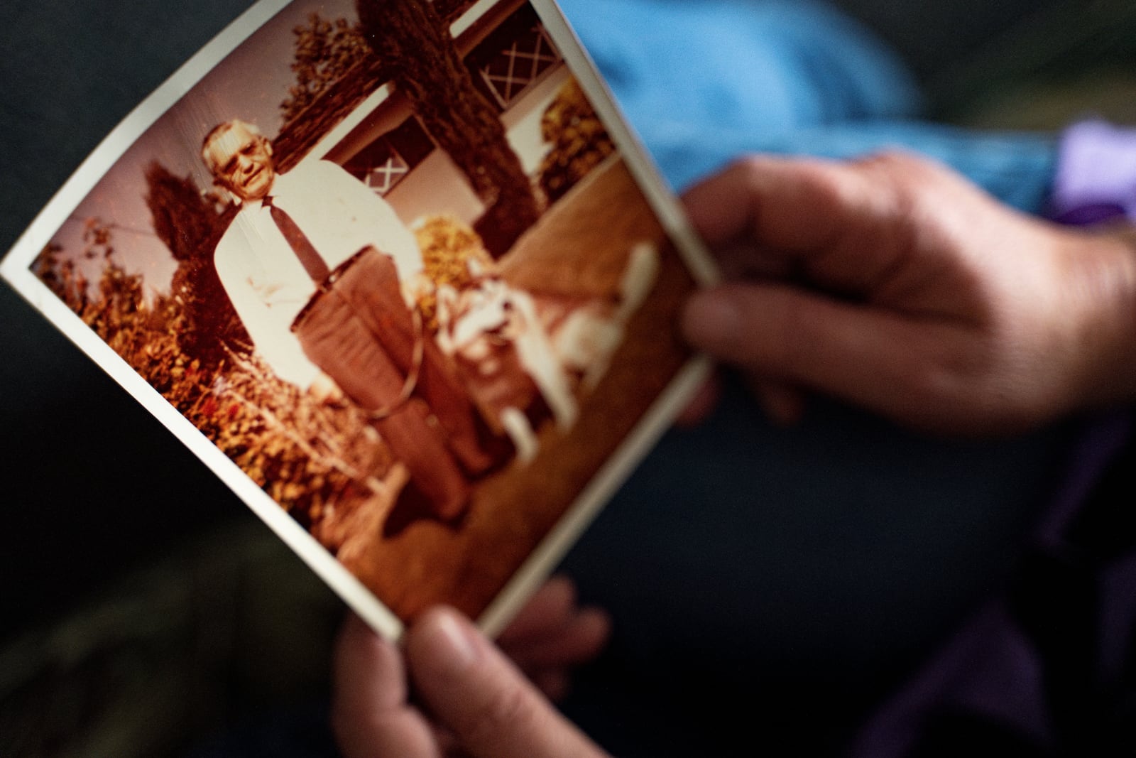 Pam Walton, a former “Two by Twos” sect member who helps track movements of allegedly predatory members through photographs and documents, holds a photograph of a deceased spiritual leader of the sect at a library Monday, Dec. 9, 2024, in Wailea, Hawaii. (AP Photo/Mengshin Lin)