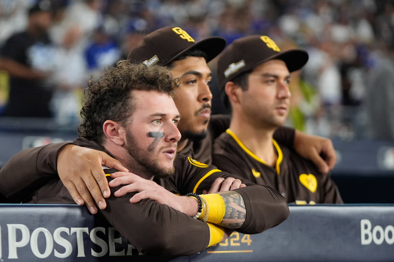 San Diego Padres center fielder Jackson Merrill, left, looks on alongside relief pitcher Jeremiah Estrada, center, and catcher Kyle Higashioka after a loss to the Los Angeles Dodgers in Game 5 of a baseball NL Division Series Friday, Oct. 11, 2024, in Los Angeles. (AP Photo/Mark J. Terrill)