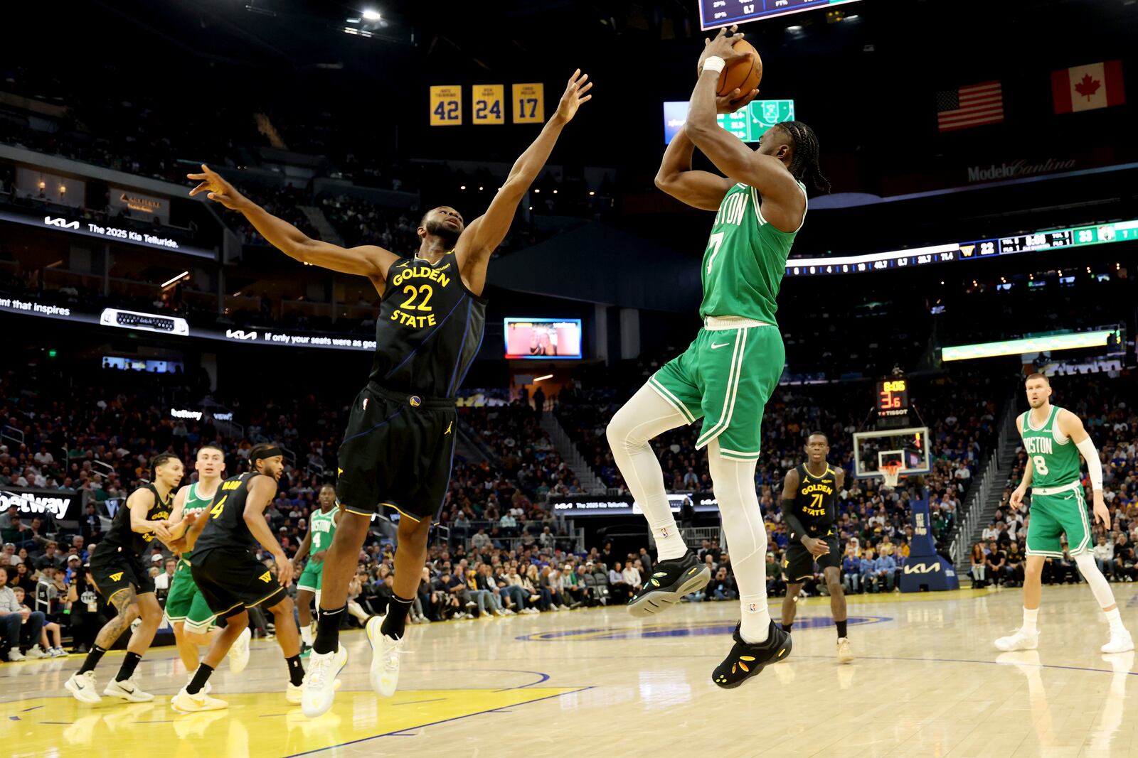 Boston Celtics guard Jaylen Brown, right, shoots against Golden State Warriors forward Andrew Wiggins (22) during the first half of an NBA basketball game in San Francisco, Monday, Jan. 20, 2025. (AP Photo/Jed Jacobsohn)