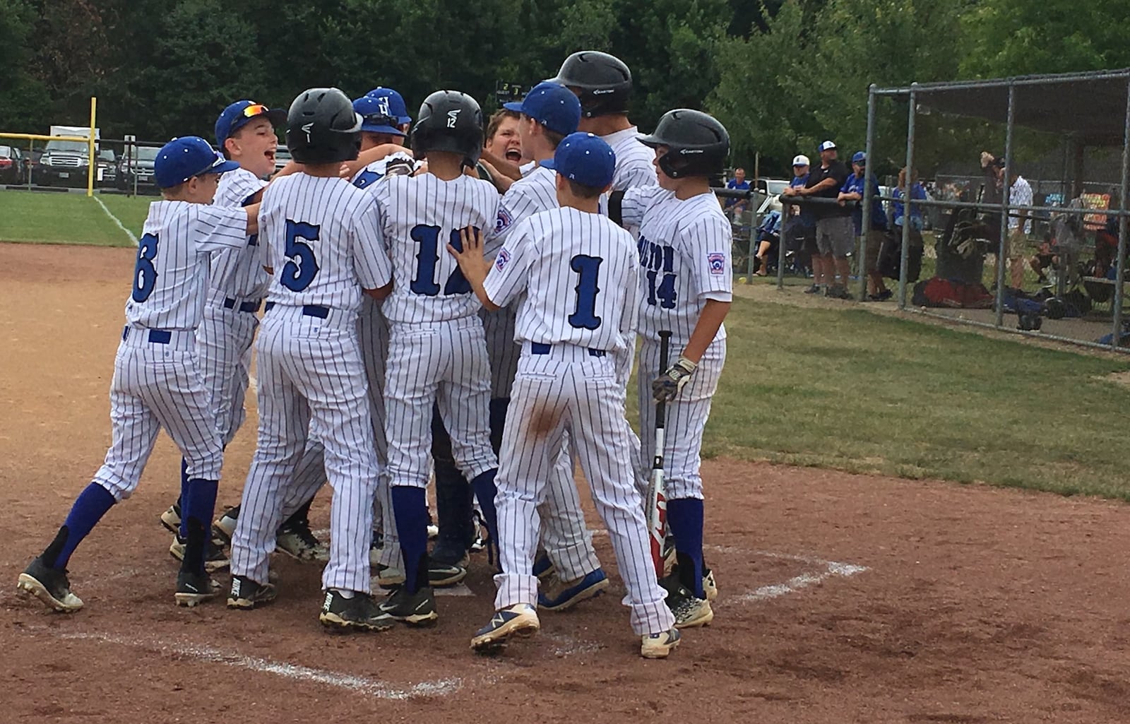 Hamilton West Side’s Noah Prewitt finds himself in the middle of a celebration Saturday afternoon after homering in the third inning against Galion at the Hoover Community Recreation Complex in North Canton. West Side, though, lost the Ohio Little League Tournament opener 10-3. RICK CASSANO/STAFF