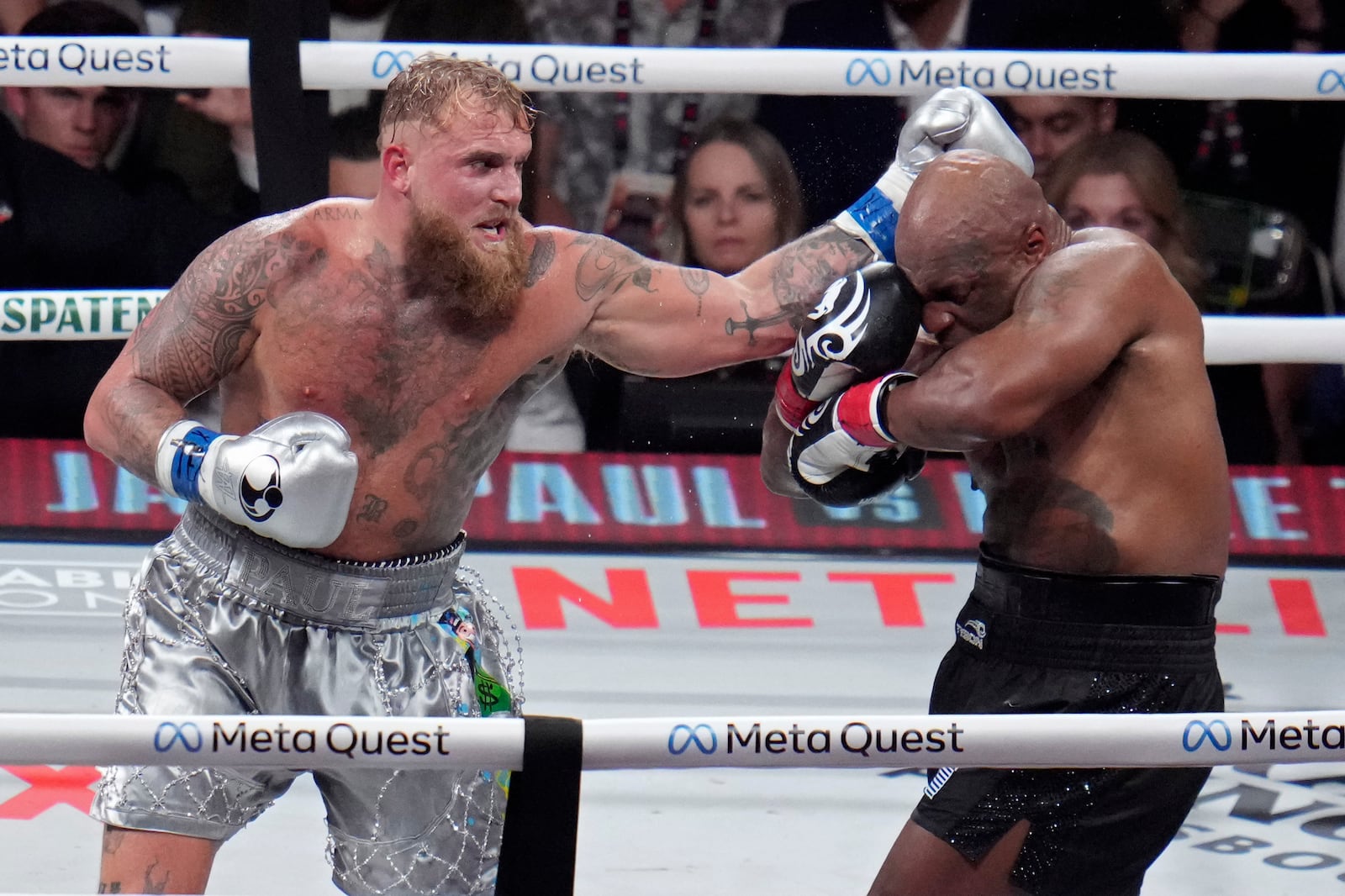 Jake Paul hits Mike Tyson during their heavyweight boxing match, Friday, Nov. 15, 2024, in Arlington, Texas. (AP Photo/Julio Cortez)