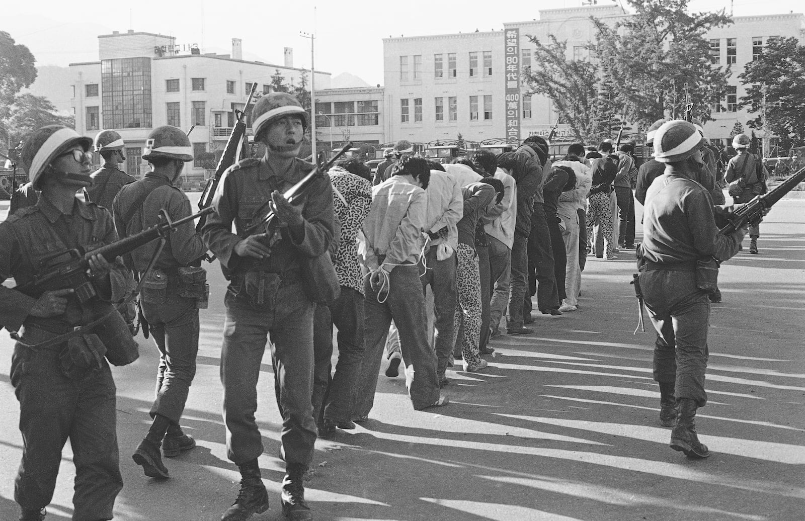 FILE - Armed South Korean government martial law troops guard captured rebels in Gwangju (Kwangju), South Korea, on May 27, 1980. The rebels were rounded up following the government's recapture by the riot-battered city. (AP Photo/Sadayuki Mikami, File)