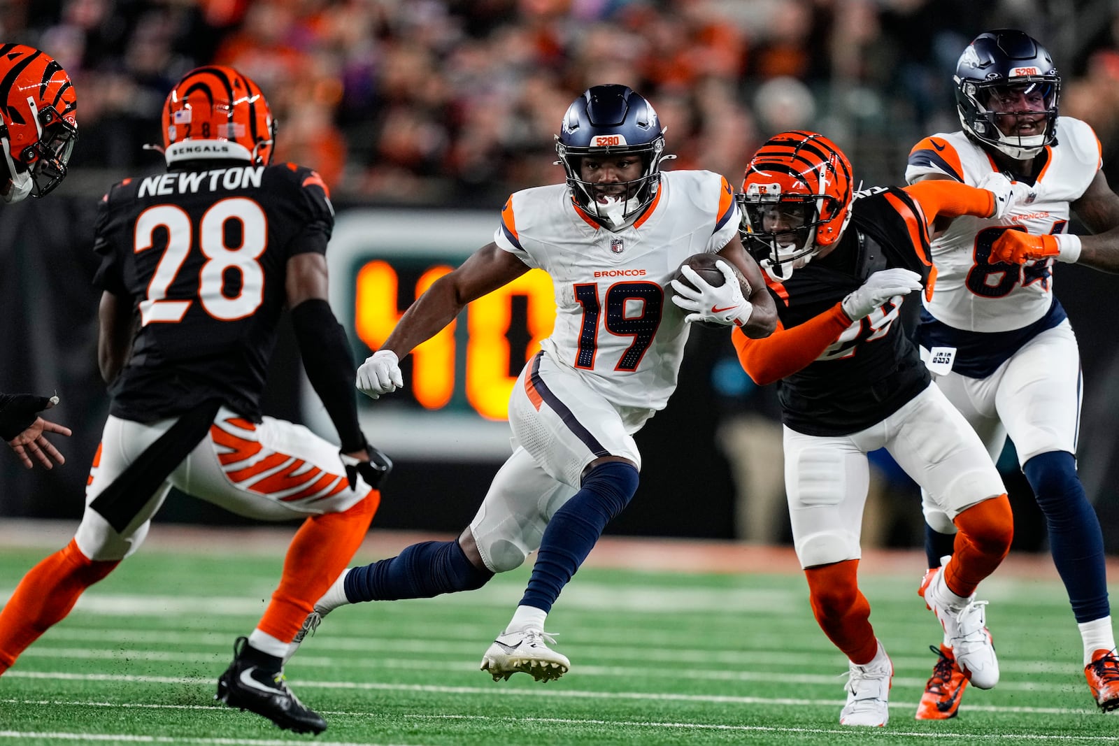 Denver Broncos wide receiver Marvin Mims Jr. (19) cuts in from top Cincinnati Bengals cornerback Josh Newton (28) during the second half of an NFL football game in Cincinnati, Saturday, Dec. 28, 2024. (AP Photo/Carolyn Kaster)