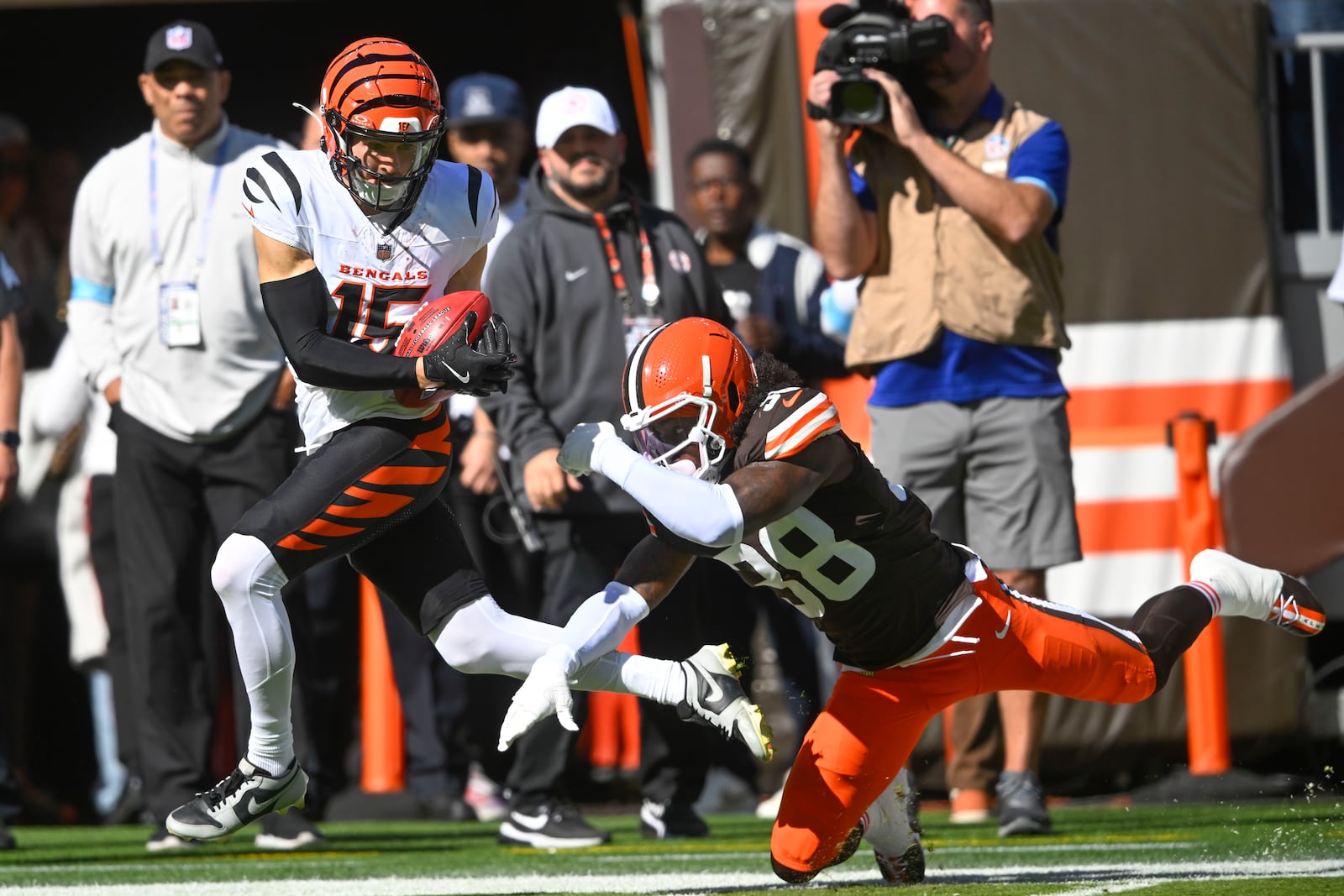 Cincinnati Bengals wide receiver Charlie Jones (15) breaks away from Cleveland Browns cornerback Tony Brown II (38) as he returns the opening kickoff for a touchdown in the first half of an NFL football game against the Cleveland Browns, Sunday, Oct. 20, 2024, in Cleveland. (AP Photo/David Richard)