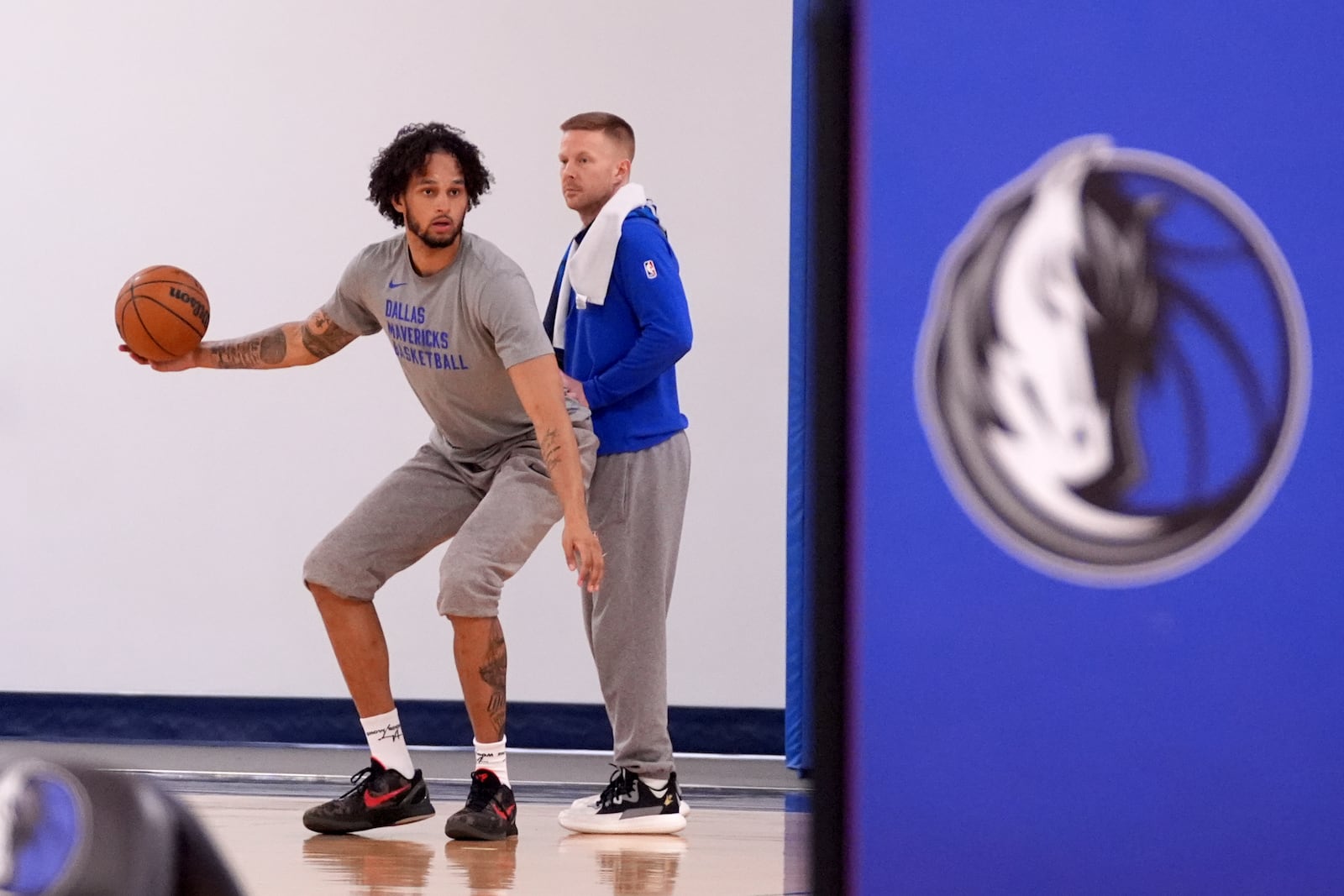 Dallas Mavericks' Dereck Lively II, left, who is recovering from injury works with assistant coach Sean Sweeney, right, at the end of NBA basketball practice at the team's training facility in Dallas, Thursday, Feb. 20, 2025. (AP Photo/Tony Gutierrez)