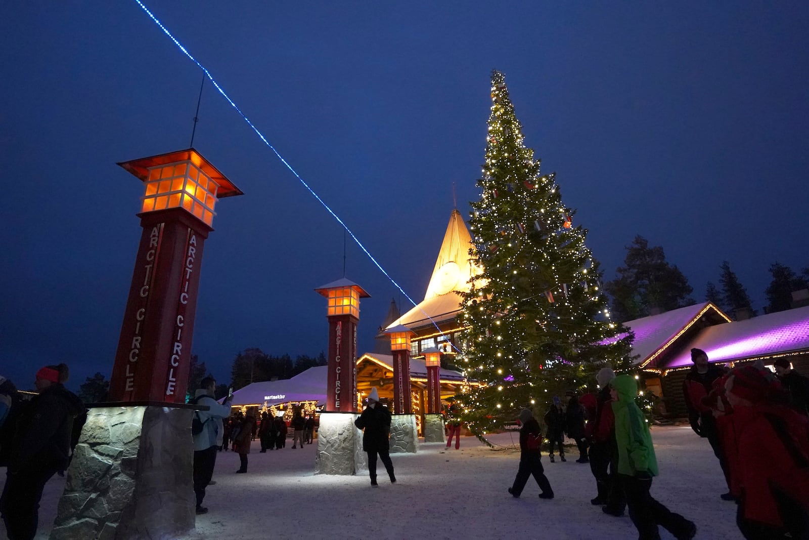 Tourists visit Santa Claus Village, a winter-themed amusement park perched on the edge of the Arctic Circle, in Rovaniemi, Finland, Wednesday, Dec. 4, 2024. (AP Photo/James Brooks)