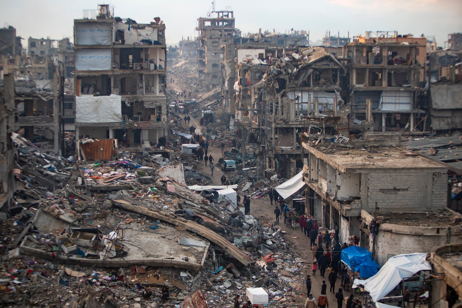 Palestinians walk in the destruction caused by the Israeli air and ground offensive in Jabaliya, Gaza Strip, Tuesday, Feb. 11, 2025. (AP Photo/Jehad Alshrafi)